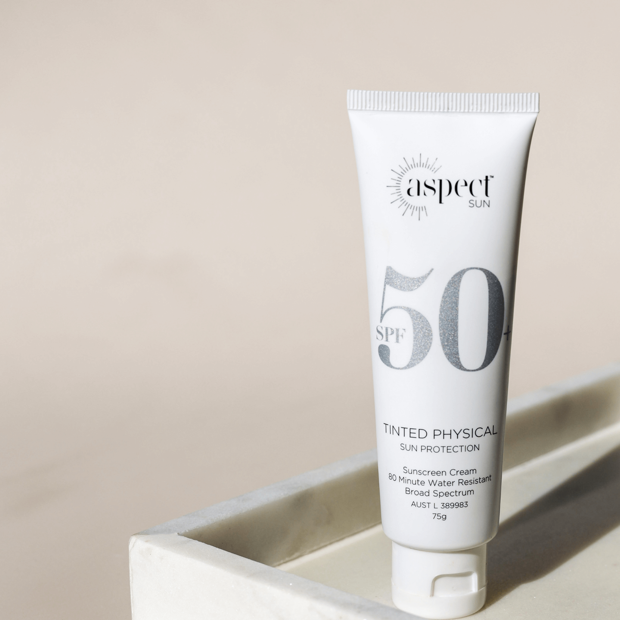 Aspect Sun tinted physical sunscreen on neutral background sitting on marble tray