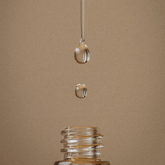 Cosmeceutical skin care range up close of product dropping into bottle on neutral background