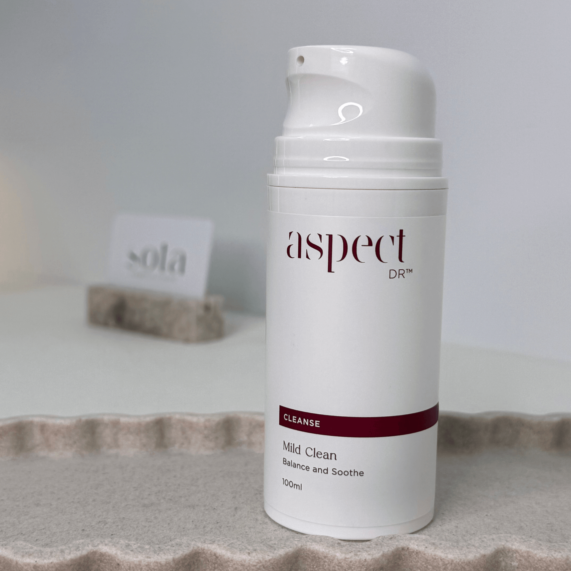 Mild Clean Aspect Dr with lid off on neutral background with sota card in distance