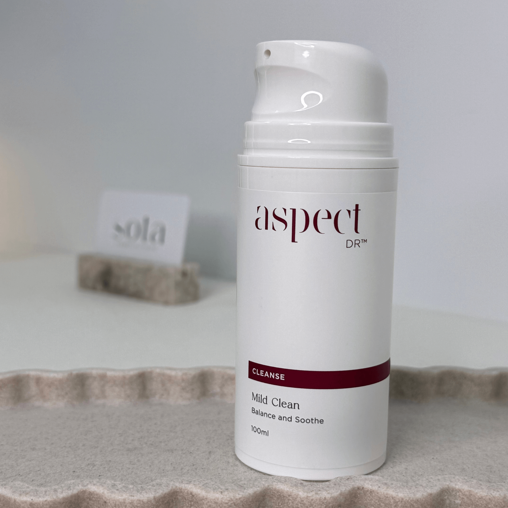 Mild Clean Aspect Dr with lid off on neutral background with sota card in distance