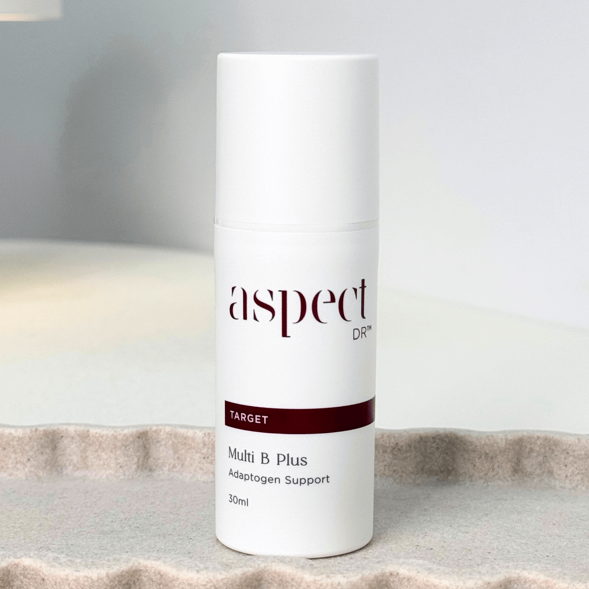 Multi B Plus Aspect Dr front of skincare on neutral background