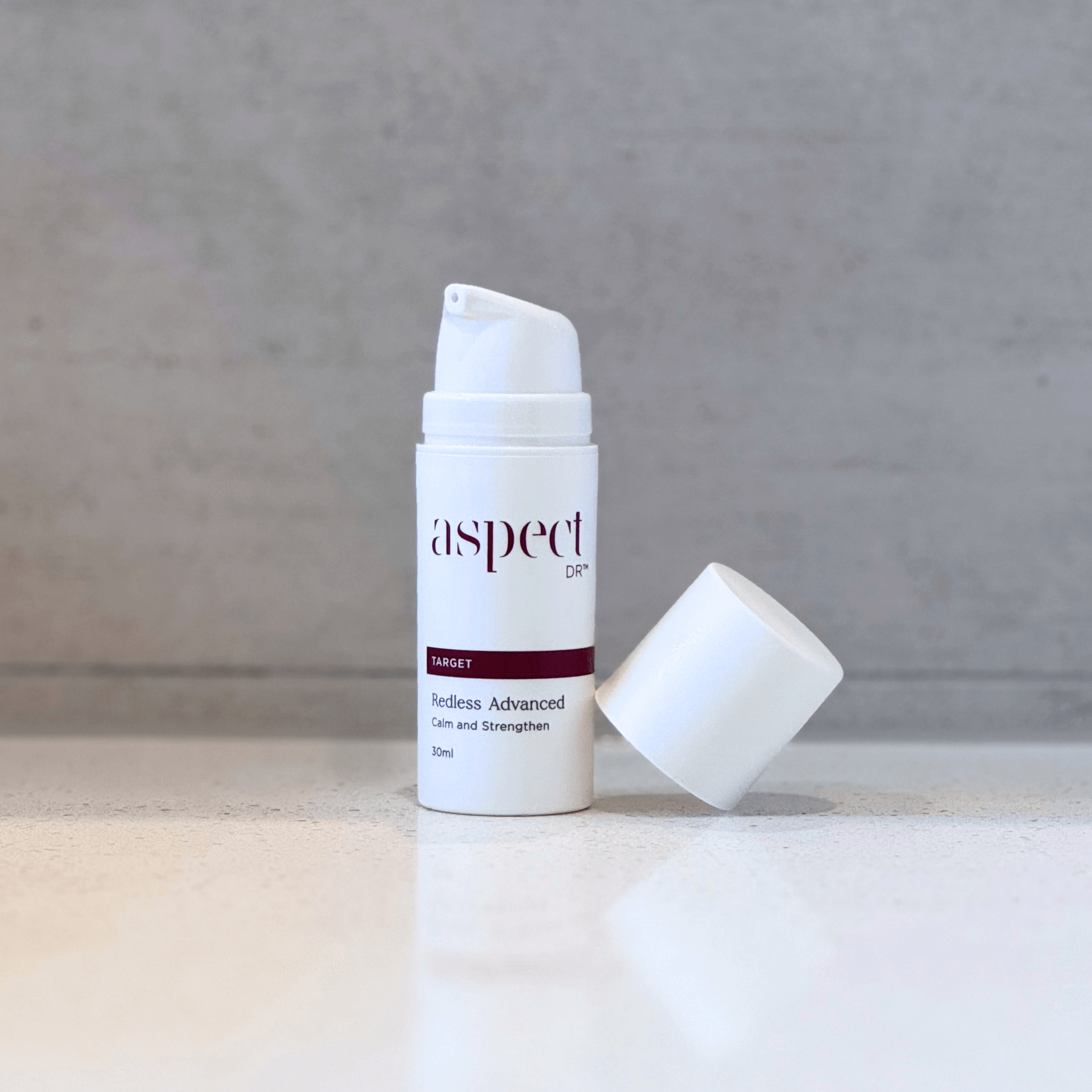 Redless Serum Aspect Dr product with lid off balancing on product