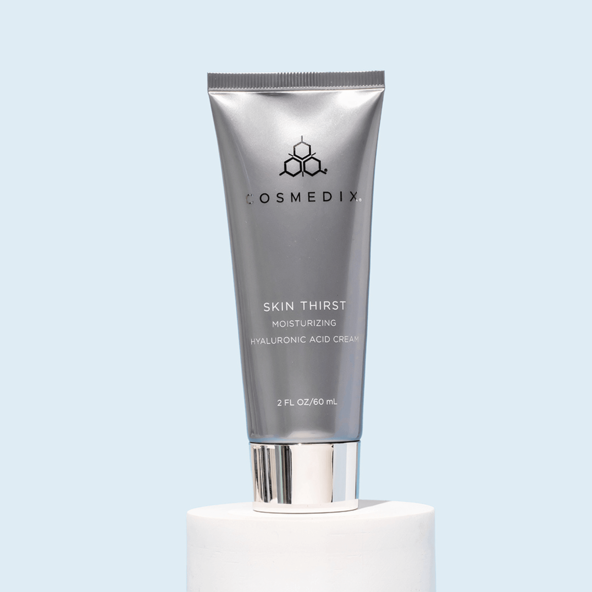 Cosmedix Skin Thirst moisturizing cream tube on a light blue background