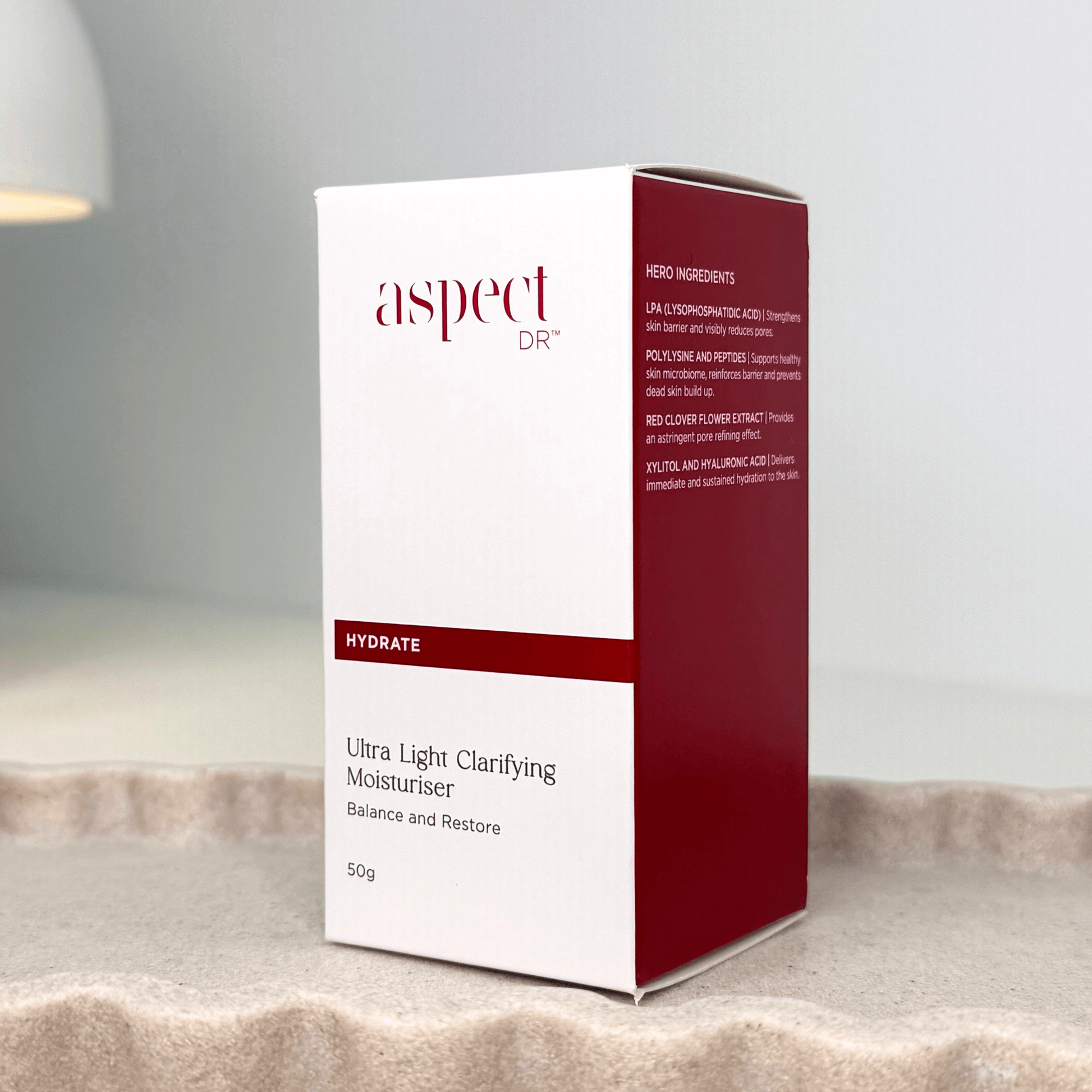 Ultra Light Clarifying Moisturiser front and side of box on neutral scalloped tray on grey background