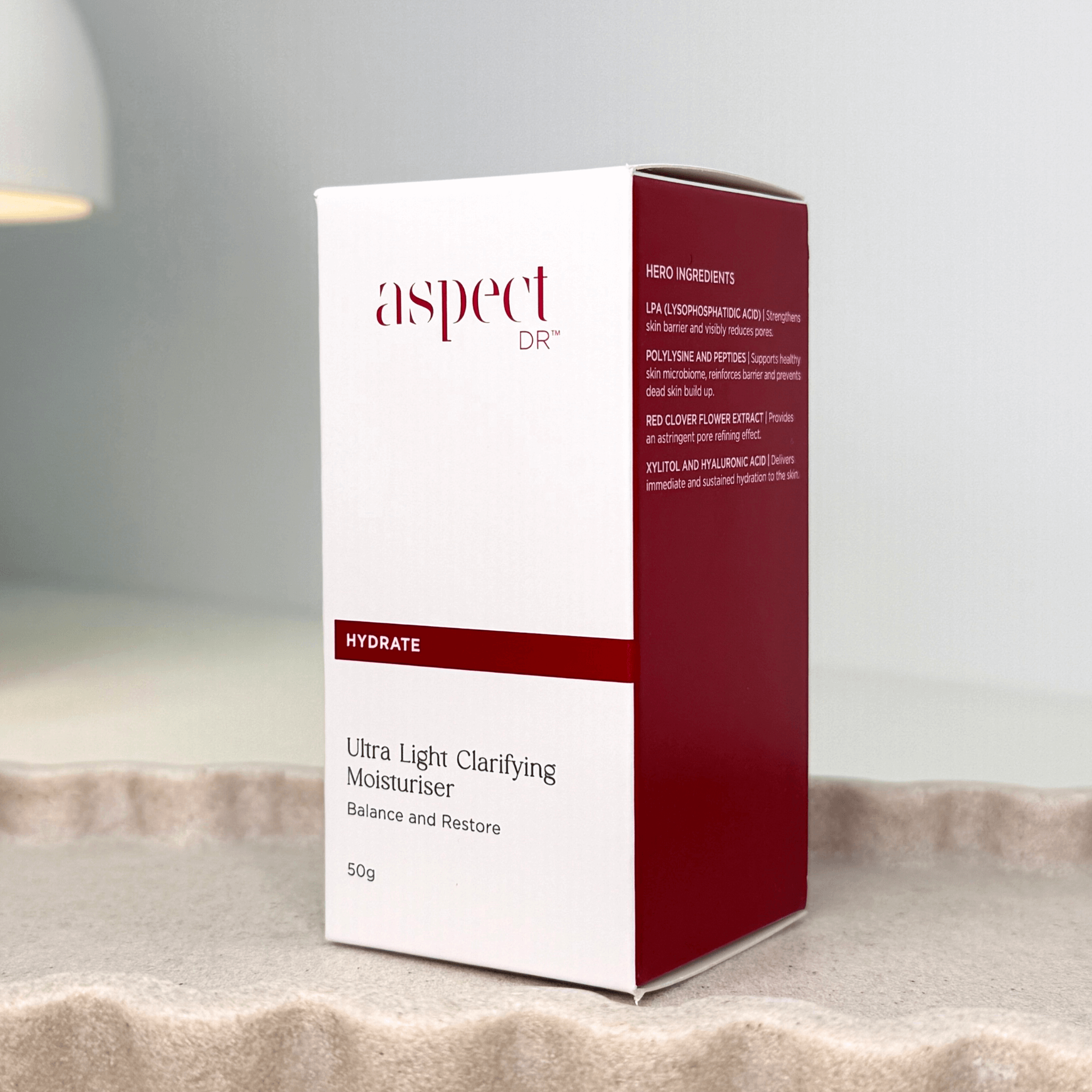 Ultra Light Clarifying Moisturiser front and side of box on neutral scalloped tray on grey background