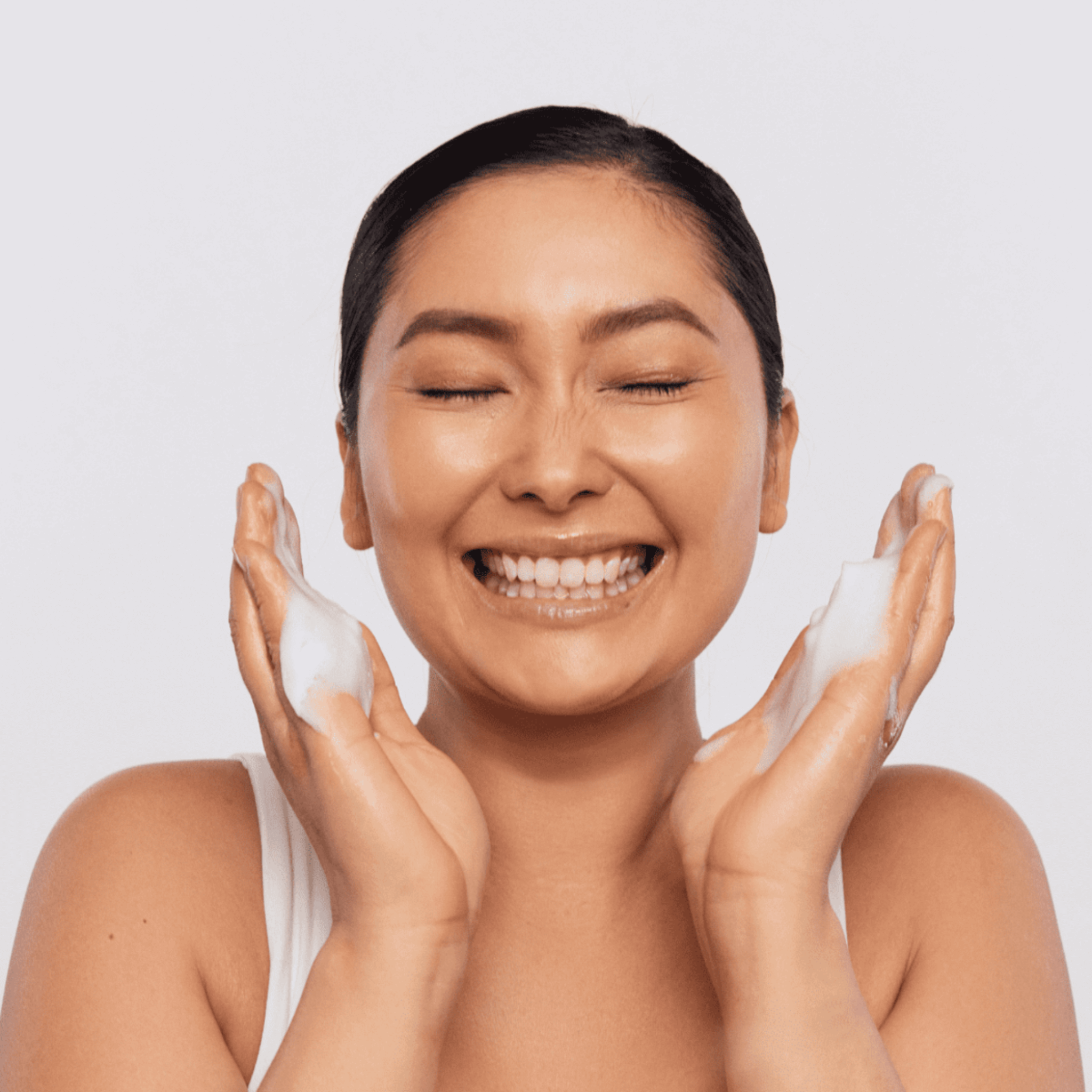 Woman applying aspect exfoliating cleanser on white background