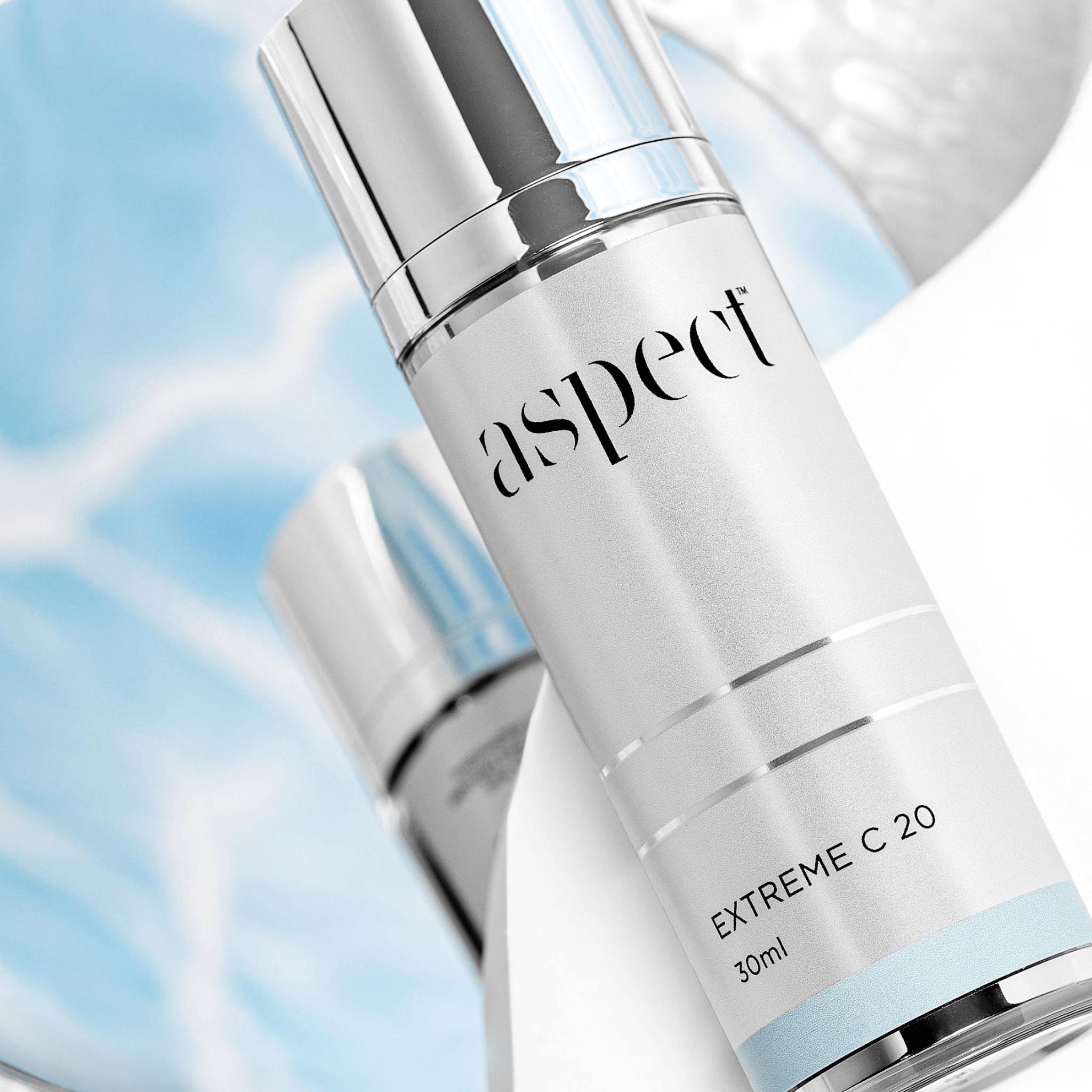 Skincare bottle labeled 'aspect' with 'EXTREME C 20' on a blurred blue background