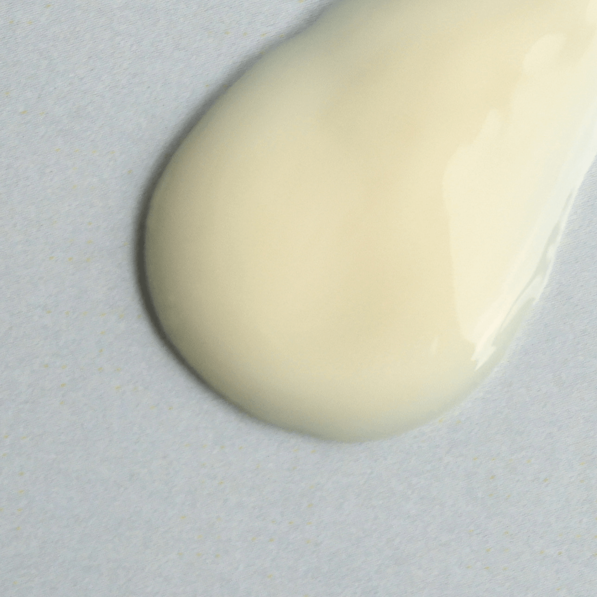 Aspect Dr Active C serum texture of glossy, smooth dollop of creamy off-white cosmetic serum on a light grey textured background.