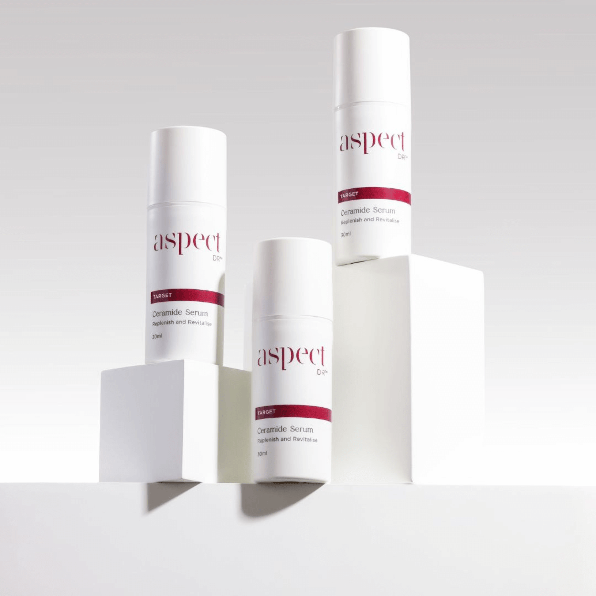 Three skincare Aspect Dr Ceramide Serum serum bottles on a light grey background