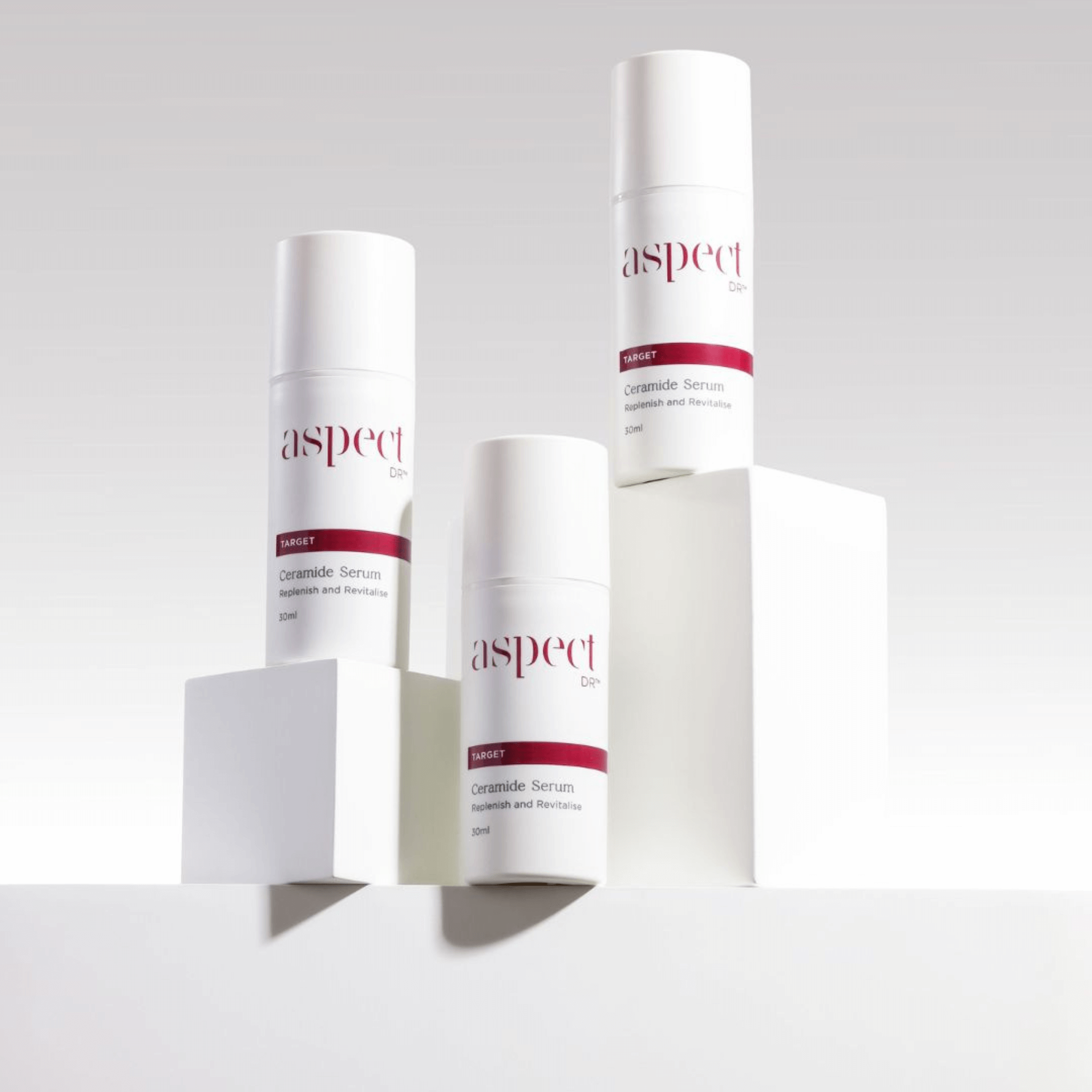 Three skincare Aspect Dr Ceramide Serum serum bottles on a light grey background