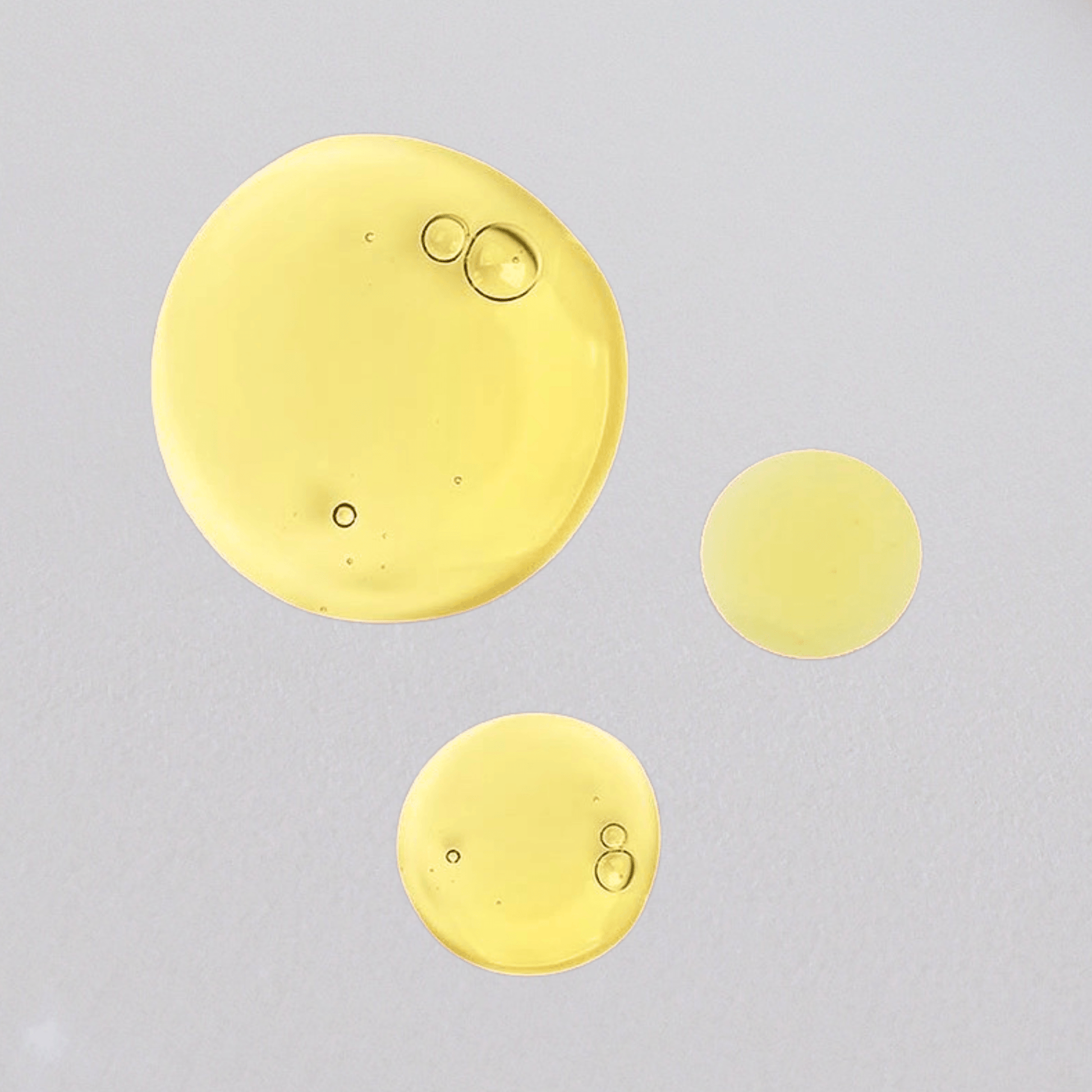 Aspect Dr Redless serum golden droplets on a light grey background