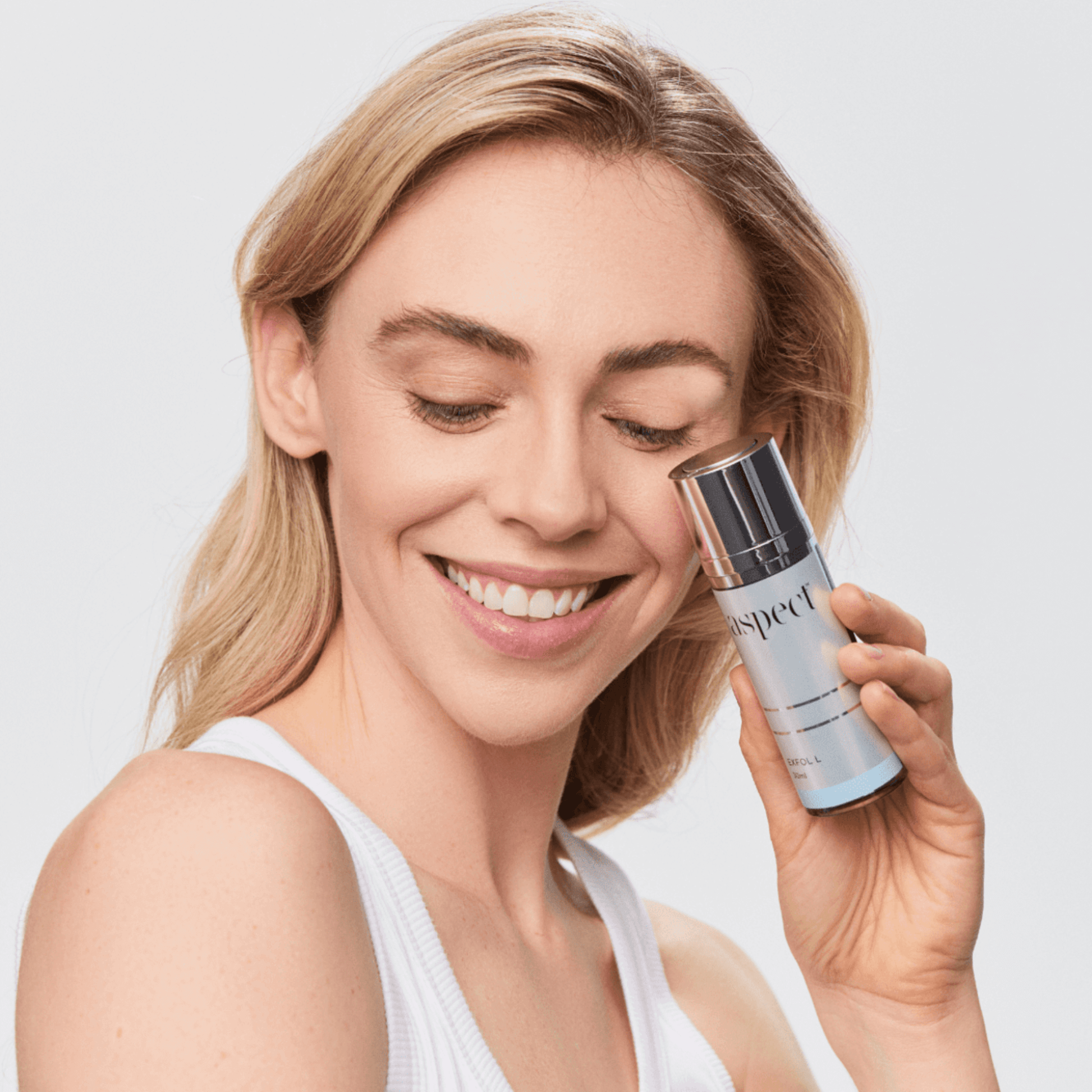 Woman holding Aspect Exfol L skincare product with a plain background
