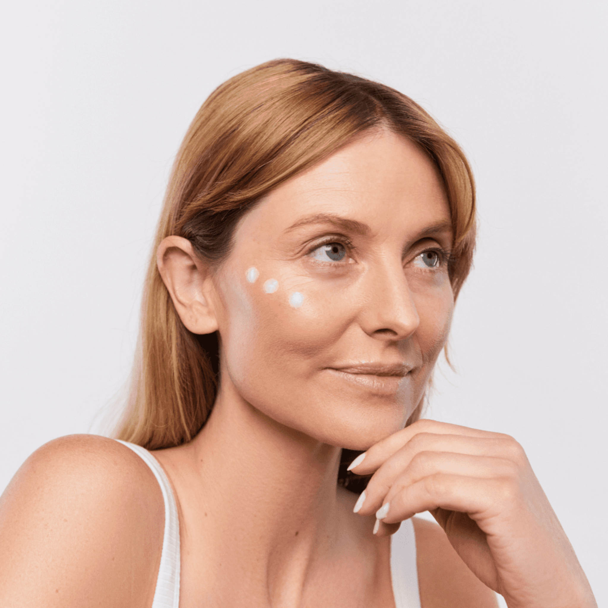 Woman with Aspect Eyelift cream applied to her face against a light background