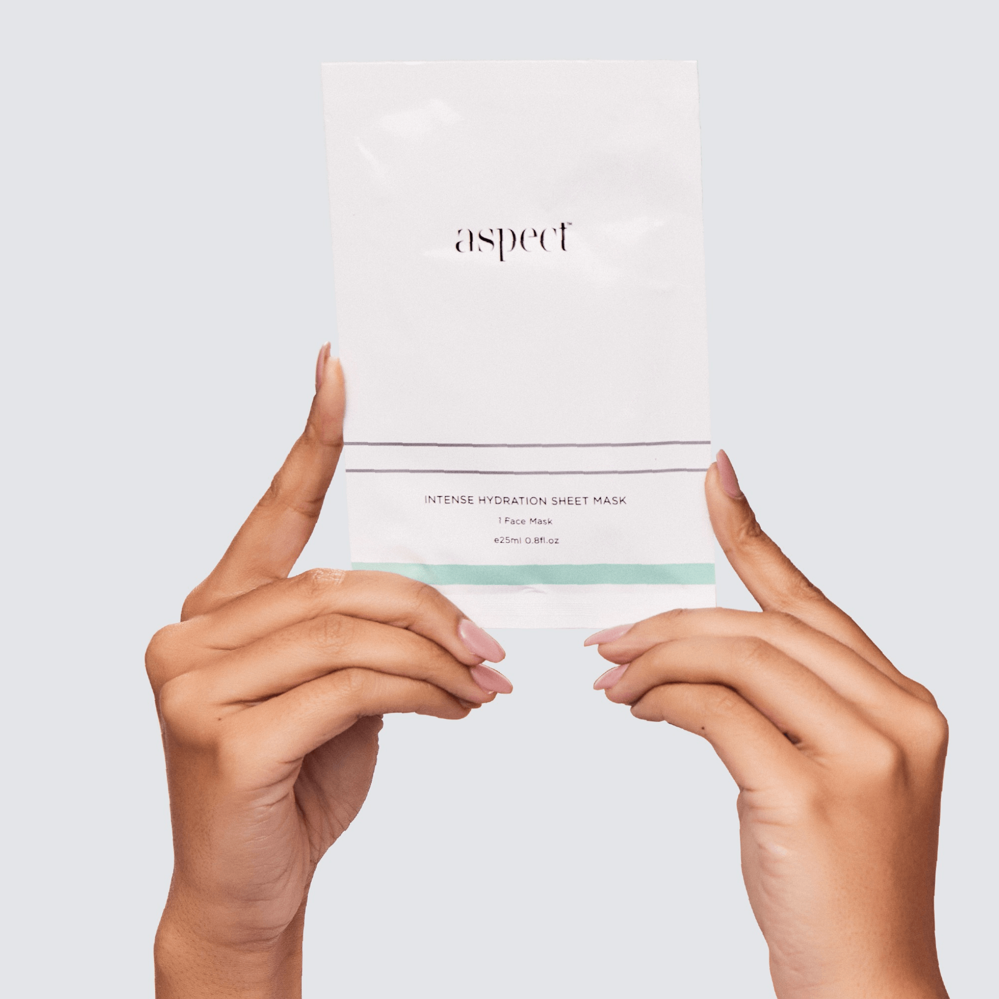 Hands holding a sheet mask with 'aspect' branding against a light grey background