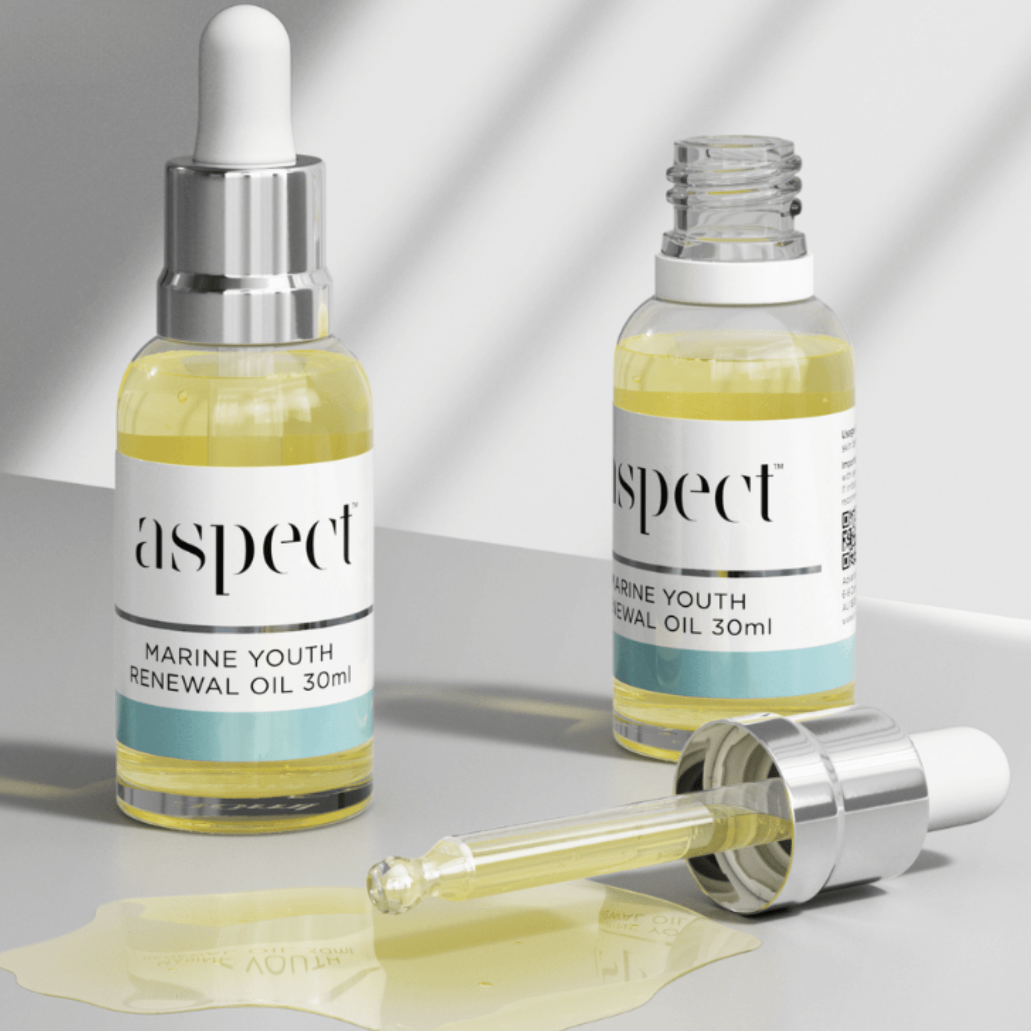 Two bottles of Aspect Marine Youth Renewal Oil with dropper on a light grey background