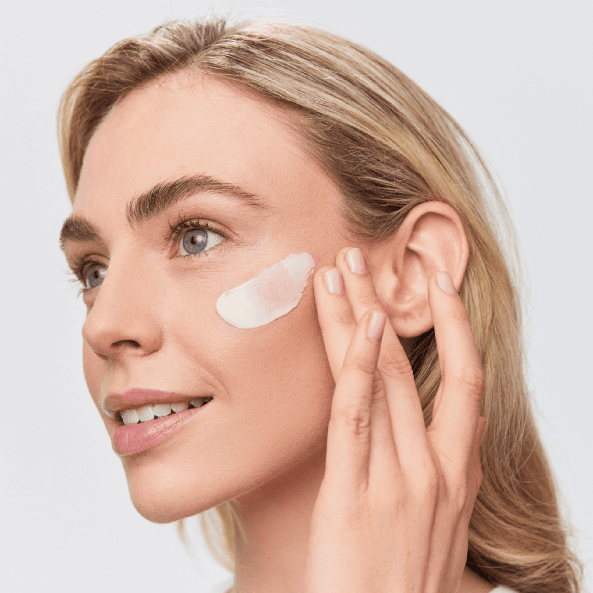 Woman applying Aspect Probiotic Mask to her face with a neutral background