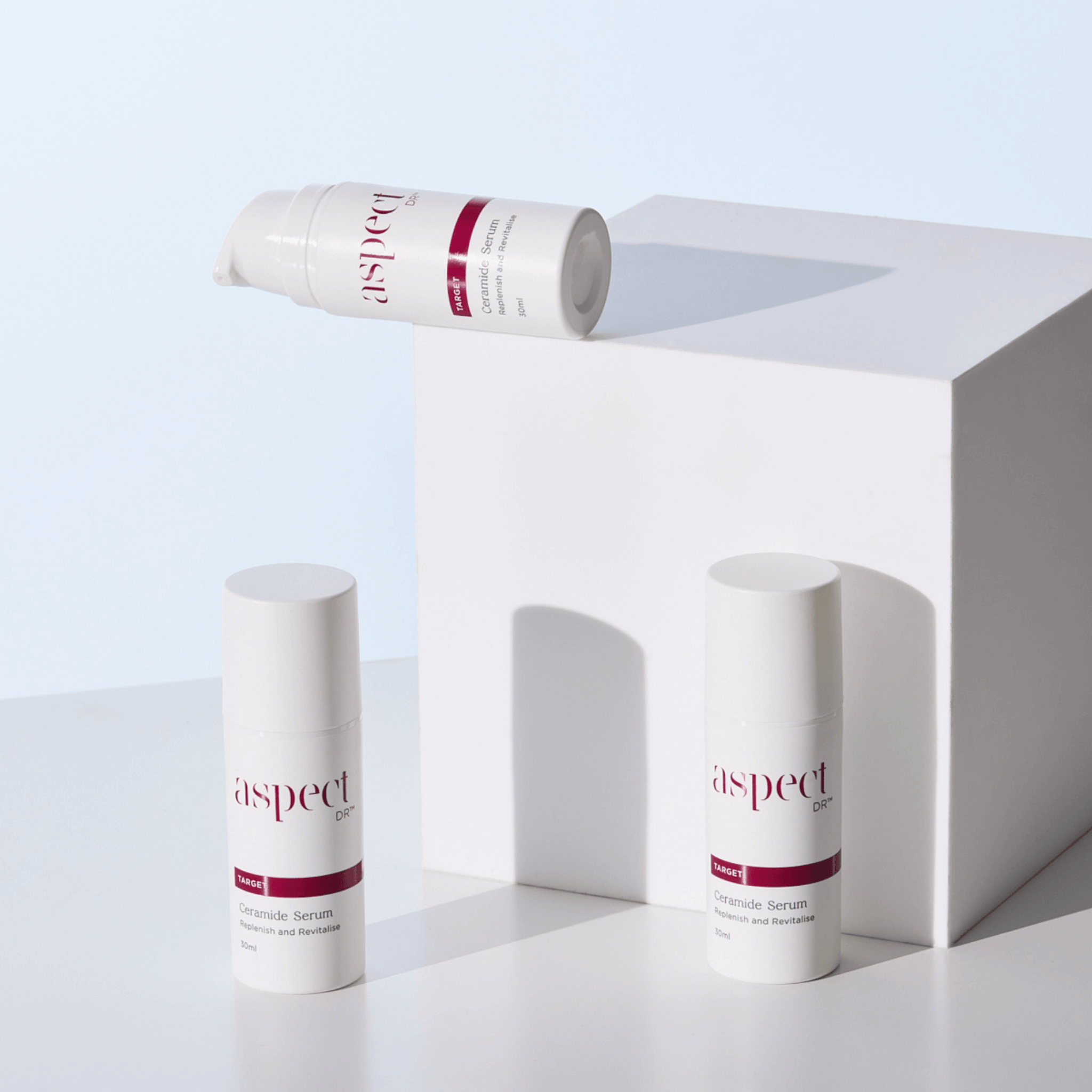 Three skincare products with 'aspect Dr' branding on a white surface and light blue background