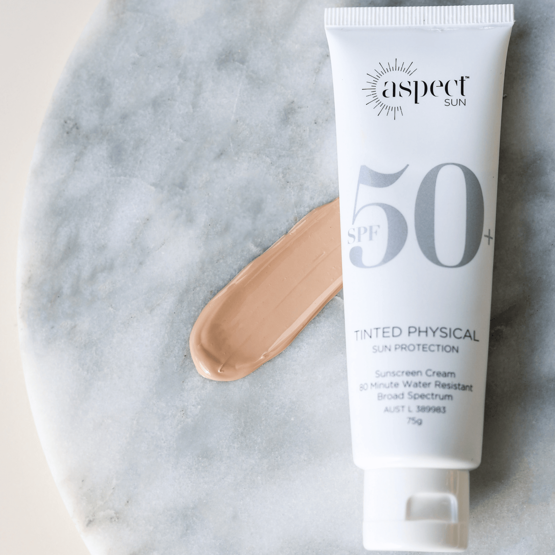 Aspect Sun sunscreen tinted physical on whit marble background with sunscreen colour swatch