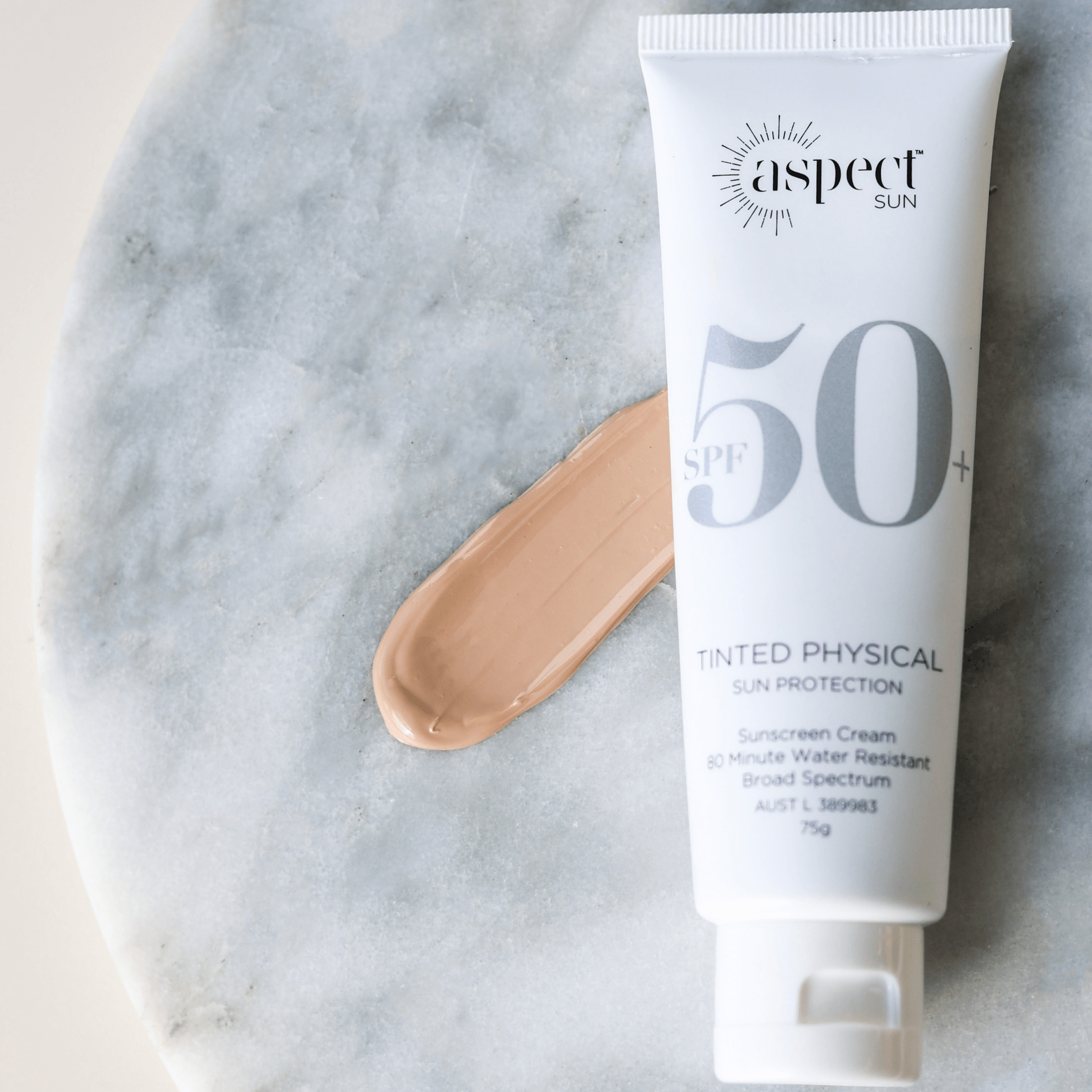 Aspect Sun sunscreen tinted physical on whit marble background with sunscreen colour swatch