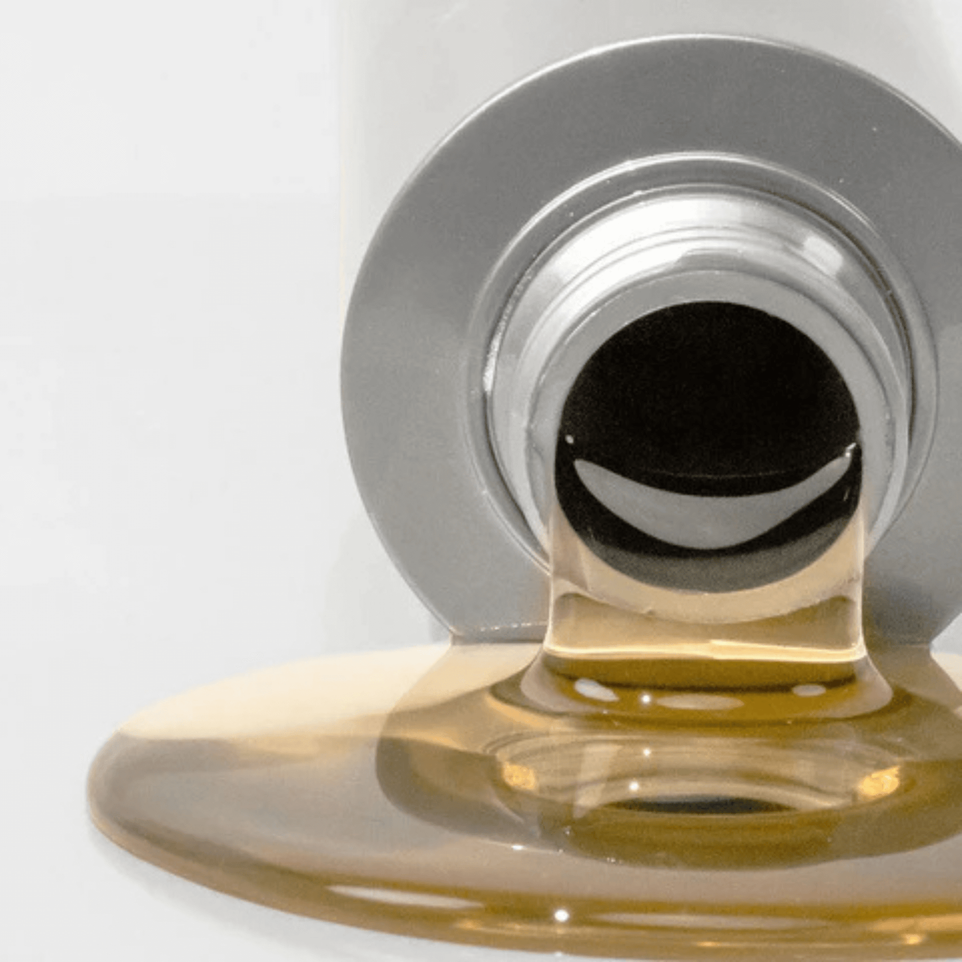 Close-up of a bottle of Benefit clean cleanser with cleanser dripping from it on a white background