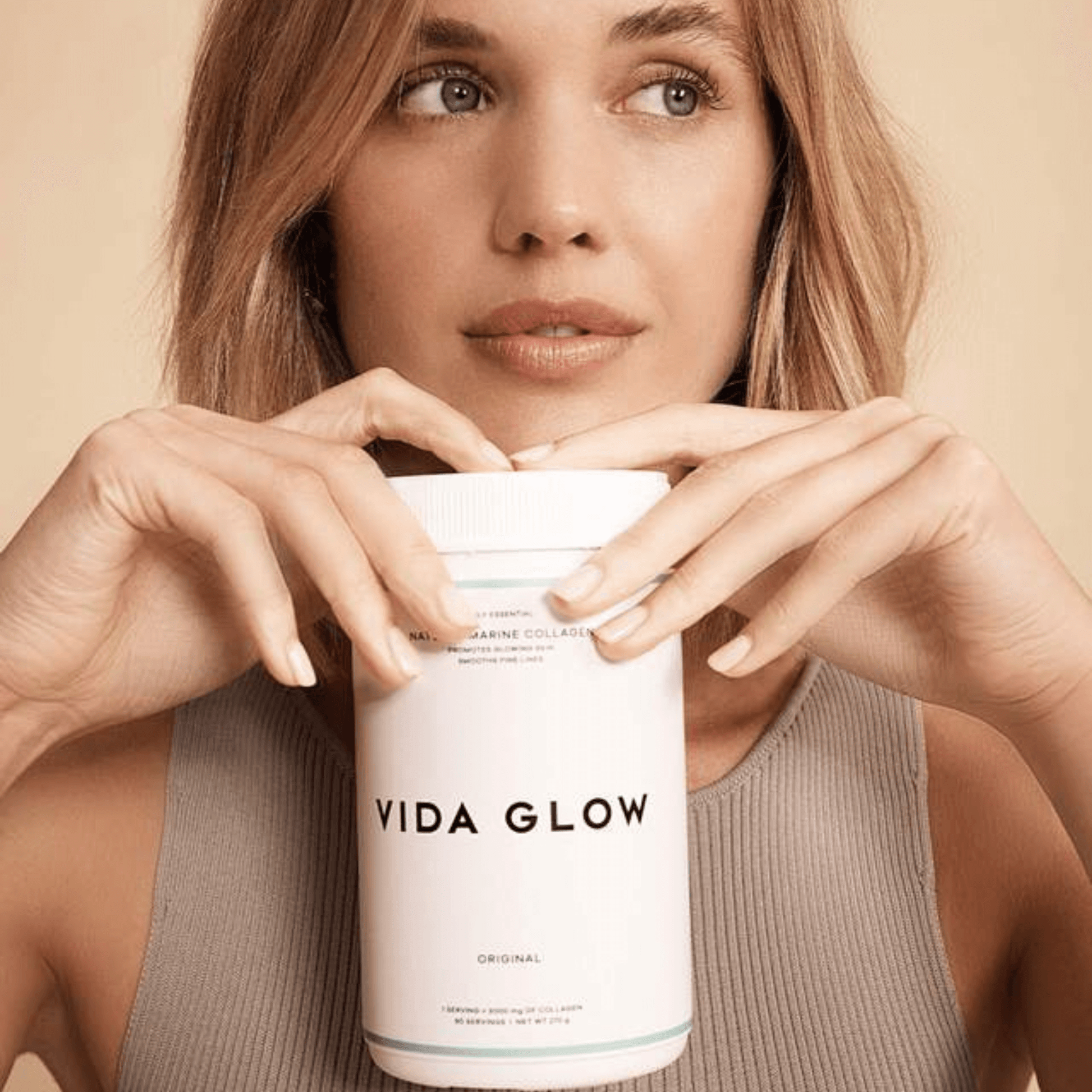 Vida Glow original collagen tub held by model