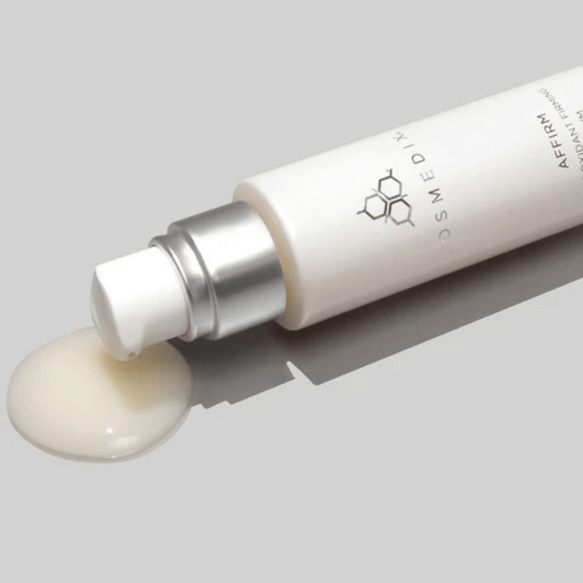 Cosmedix Affirm Serum with a droplet of cream on a grey background