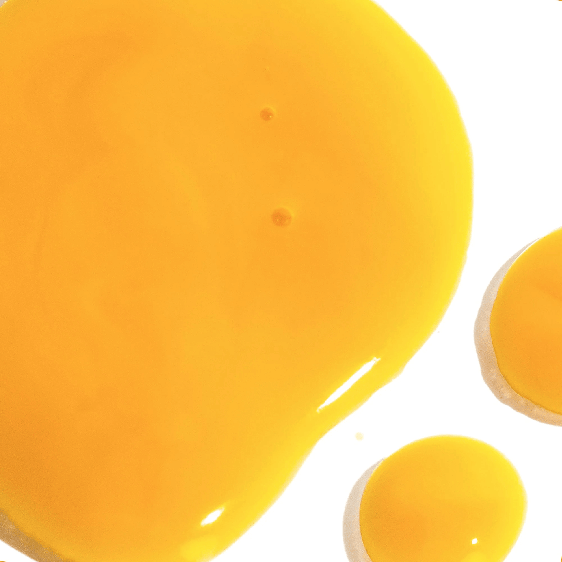 Close-up of a yellow clarity serum droplets on white background