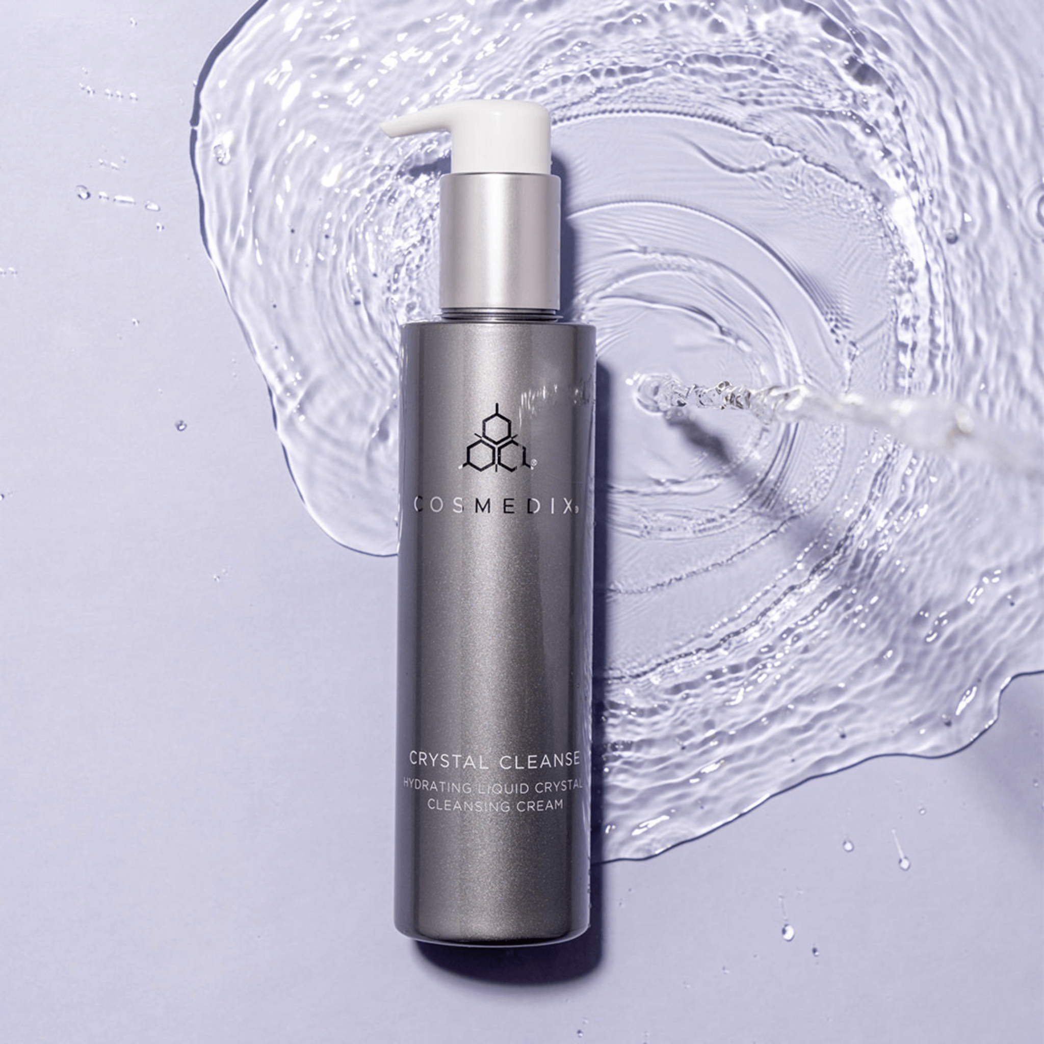 Cosmedix Crystal Cleanse bottle on a light purple background with water droplets