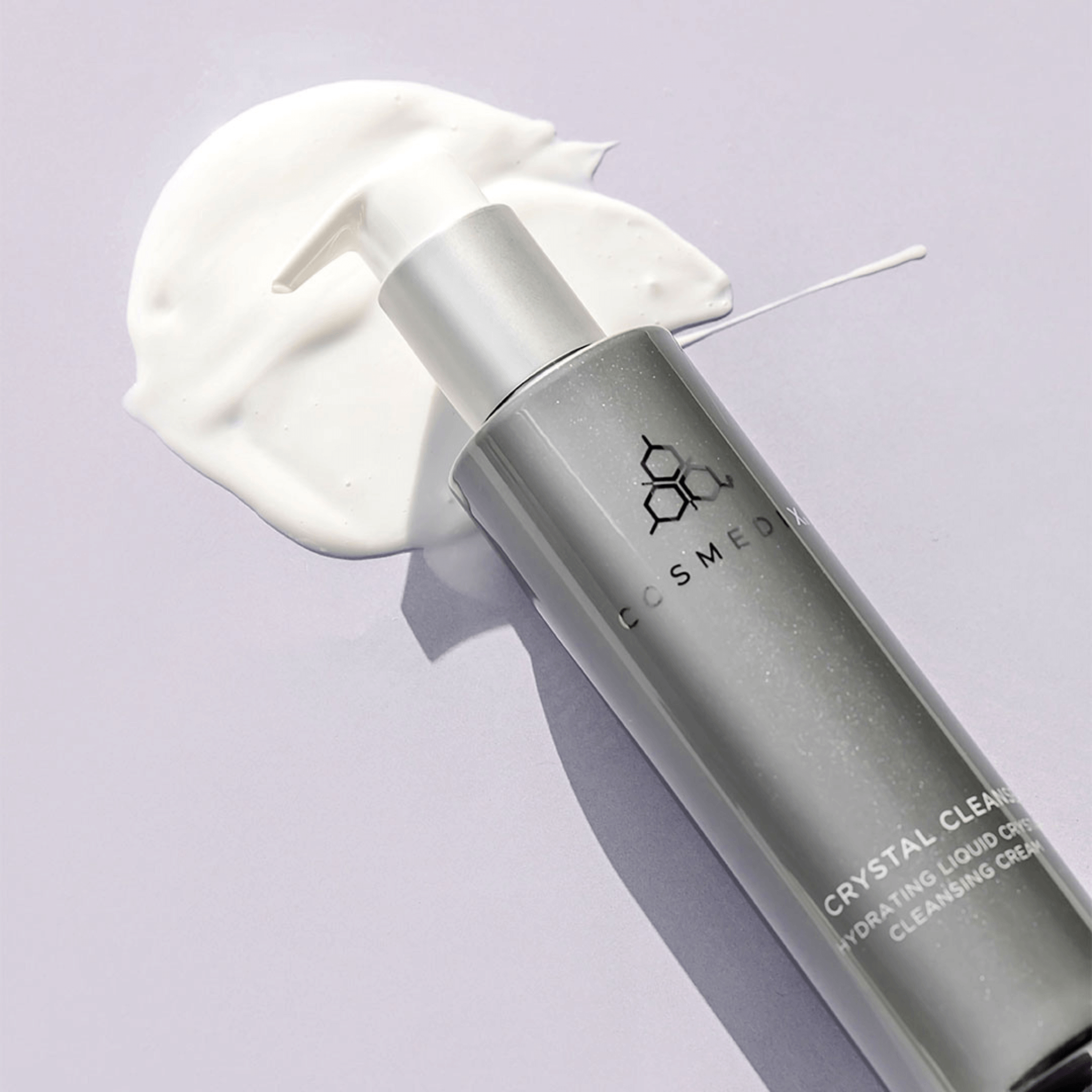 Cosmedix Cleanser Crystal bottle with cream on a light purple background