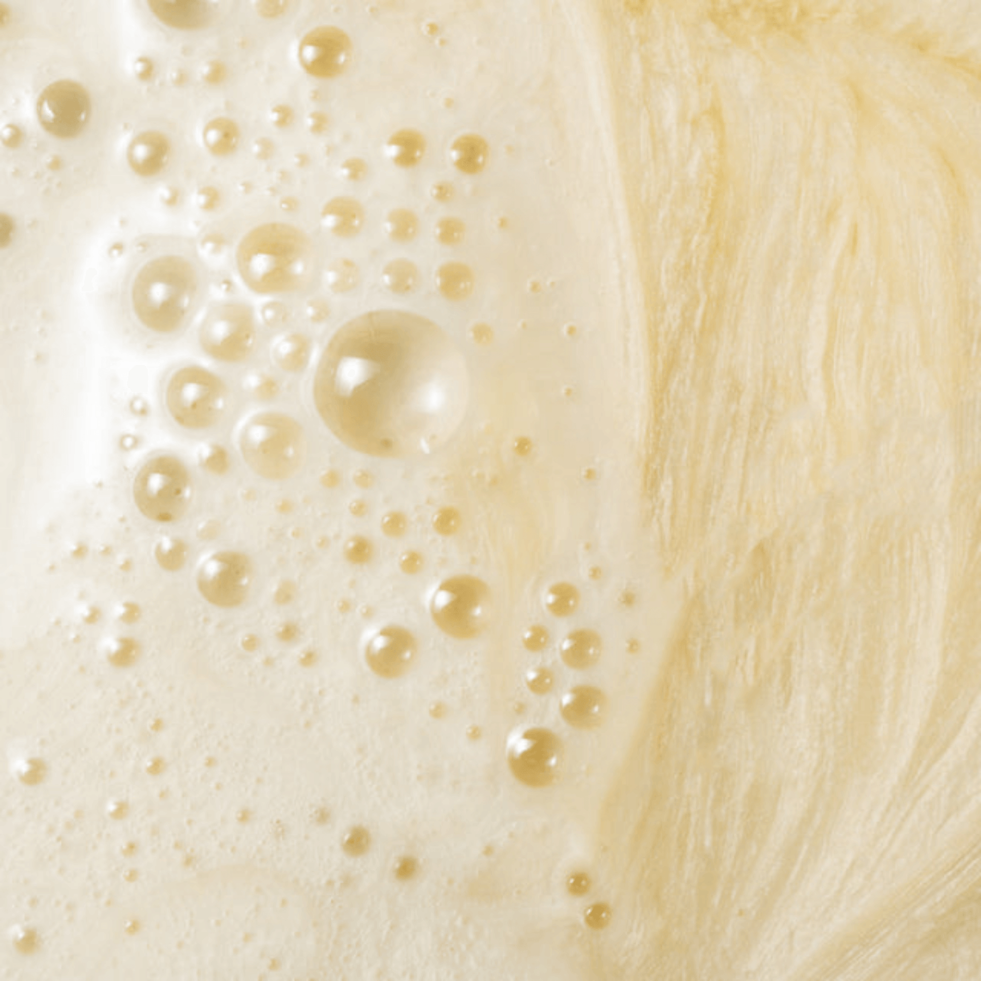 Close-up of a creamy beige COSMEDIX ELITE RX clean cleanser texture with bubbles