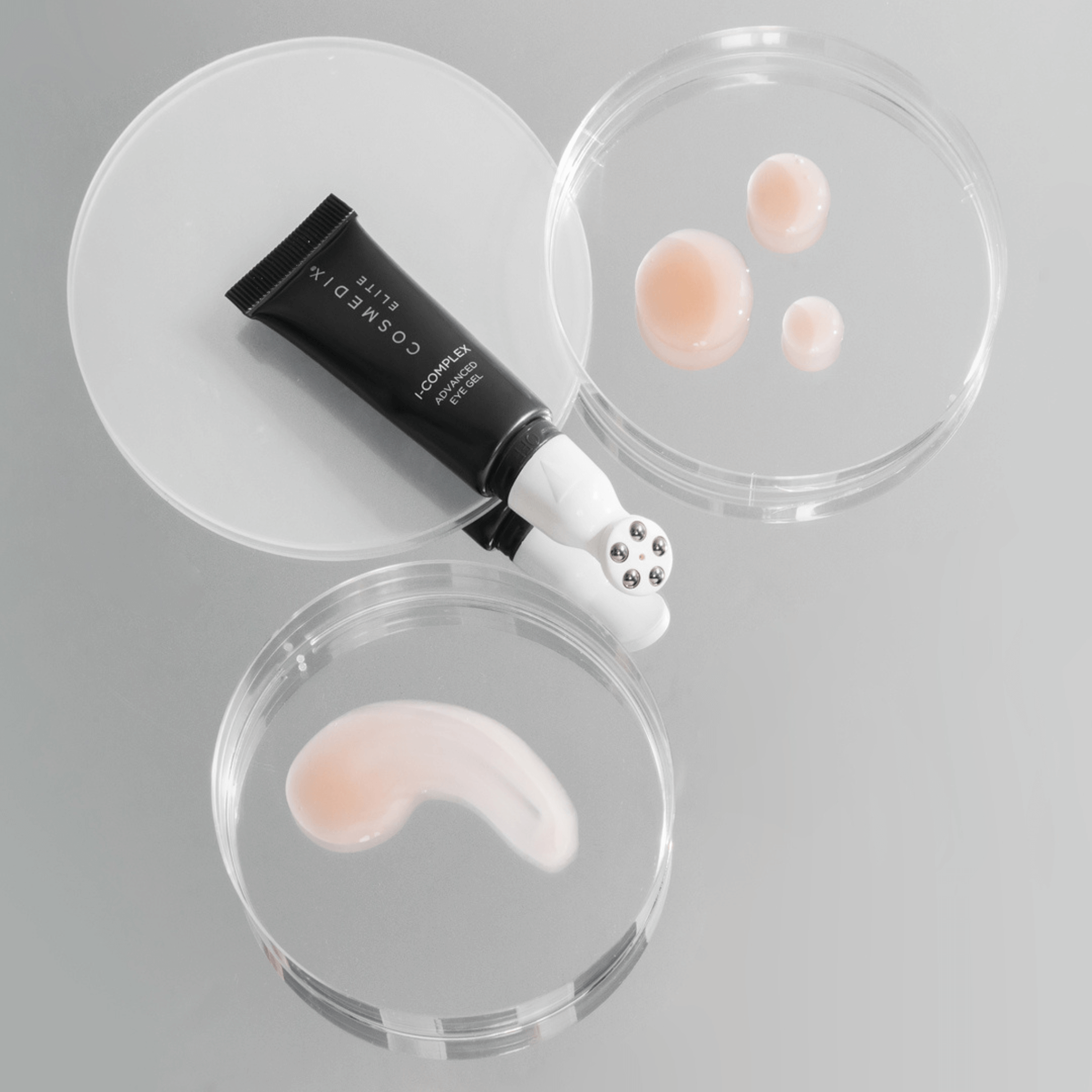 Cosmedix Elite I complex advanced eye gel on grey background with swatches of eye cream on petri dish