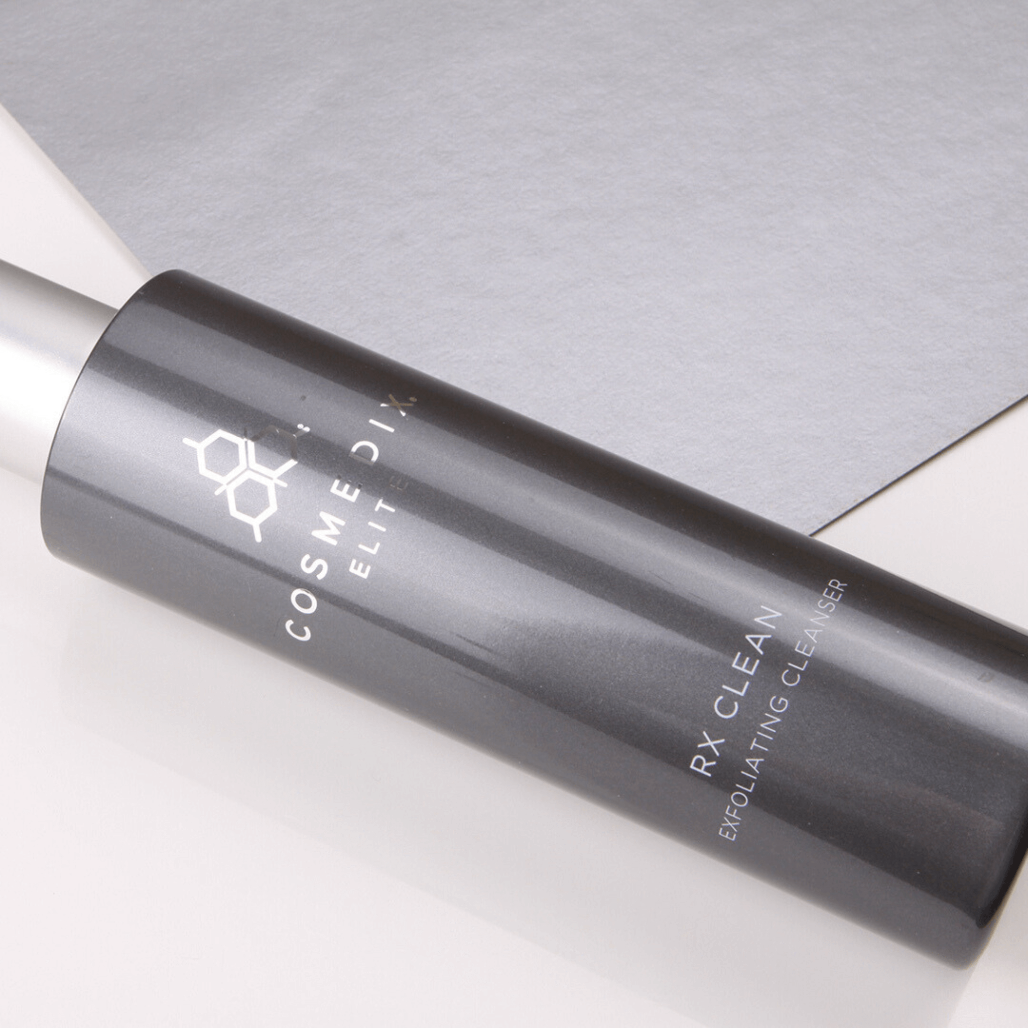 COSMEDIX ELITE RX clean cleanser bottle laying on a light grey background