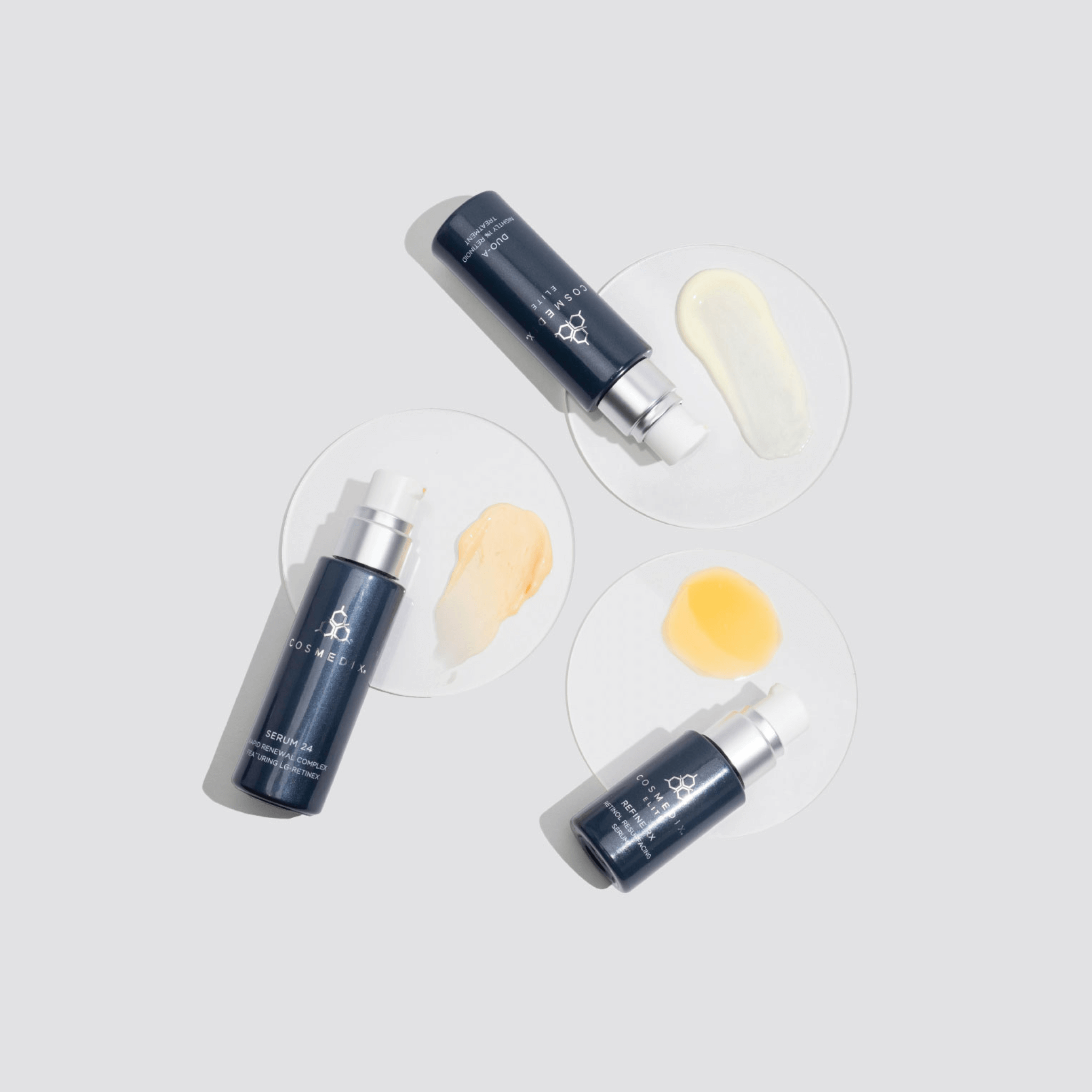 Three Cosmedix Elite serum skincare bottles with a light grey background