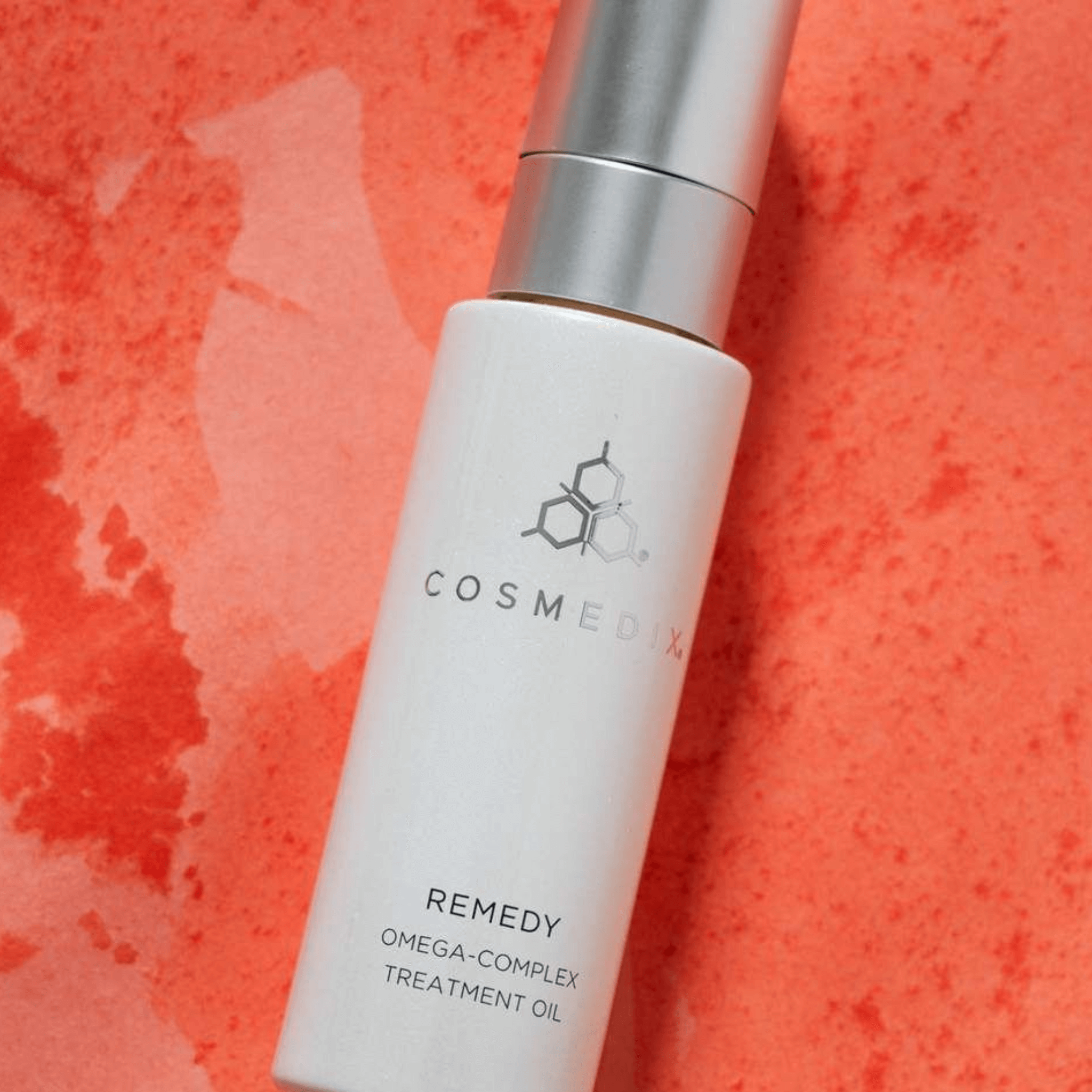 Cosmedix Remedy Omega-Complex Treatment Oil bottle on a red textured background