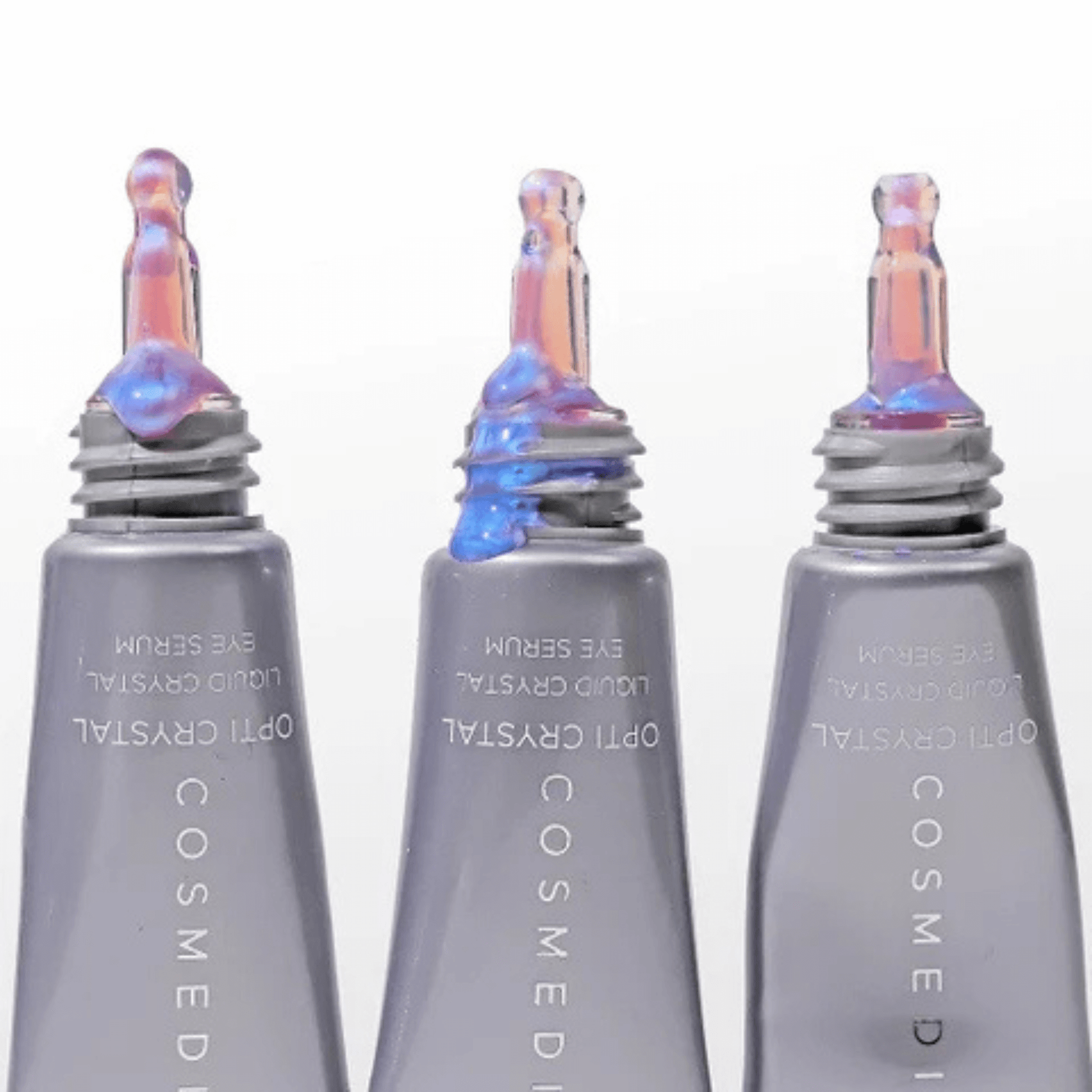 Three Cosmedix eye serum bottles with iridescent caps on a white background