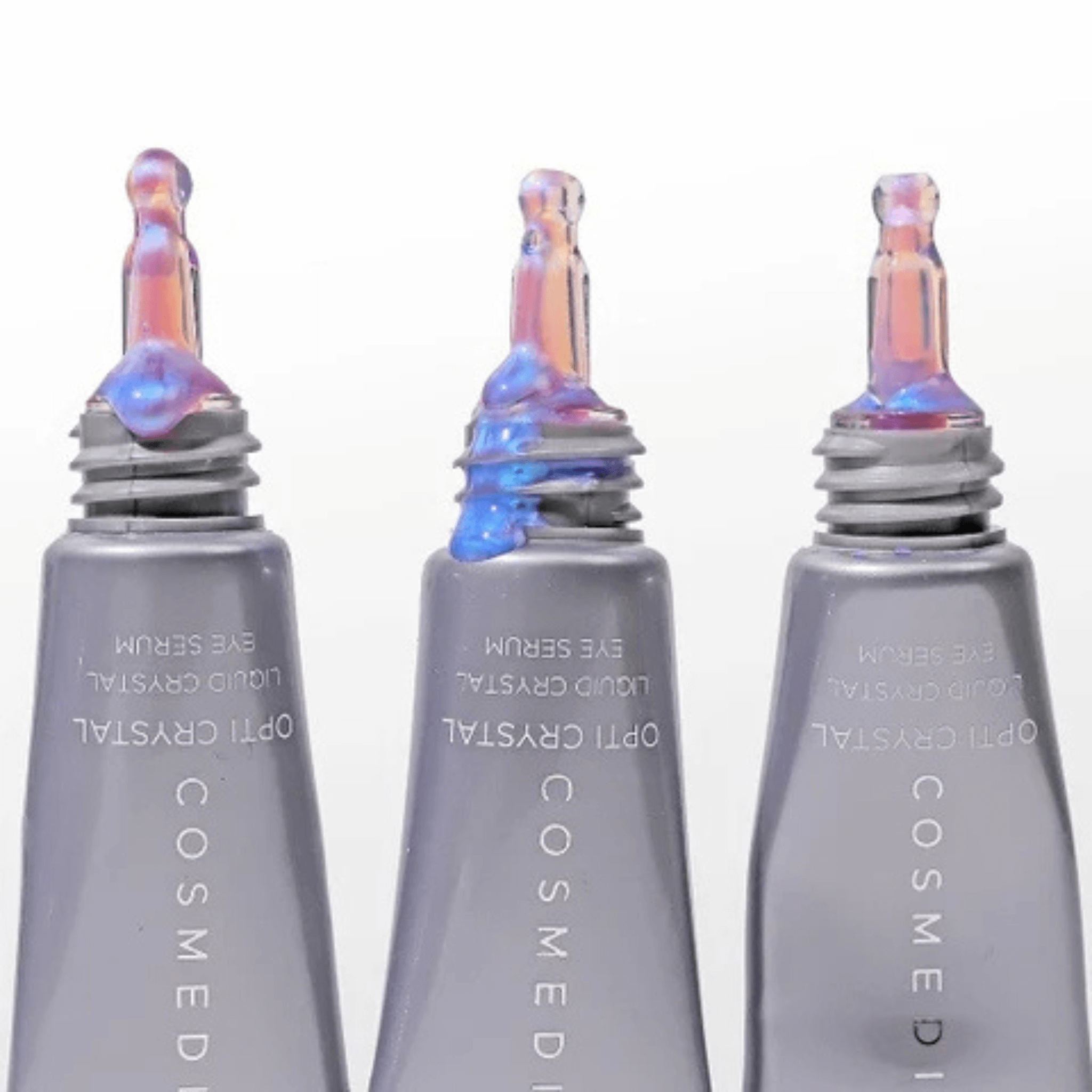 Three Cosmedix eye serum bottles with iridescent caps on a white background