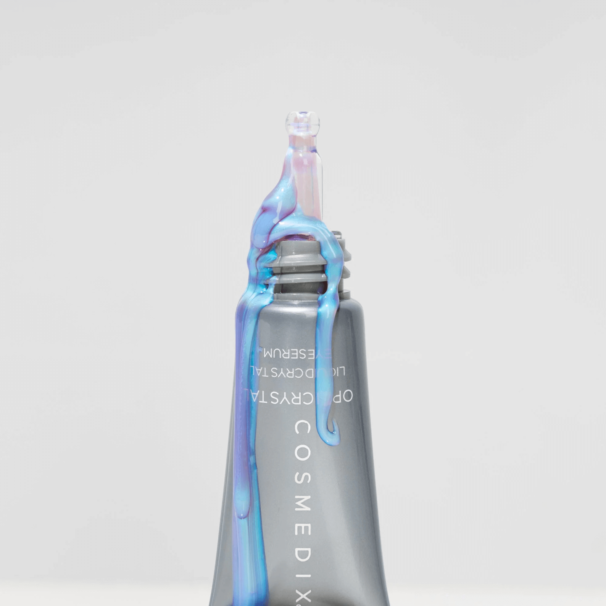 Cosmedix eye serum bottle with colourful eye cream on a light grey background