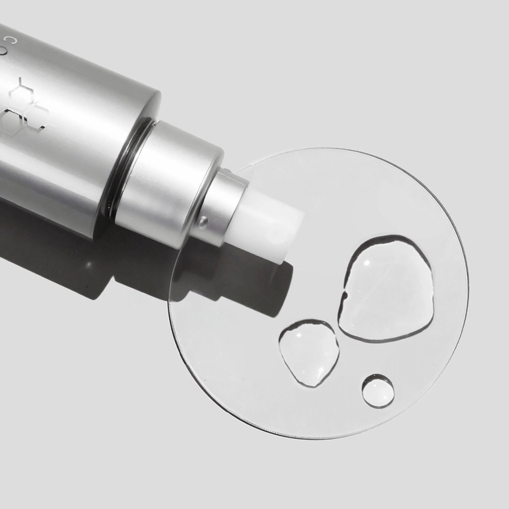 Close-up of Cosmedix Purity balance clear liquid droplet on a light grey background