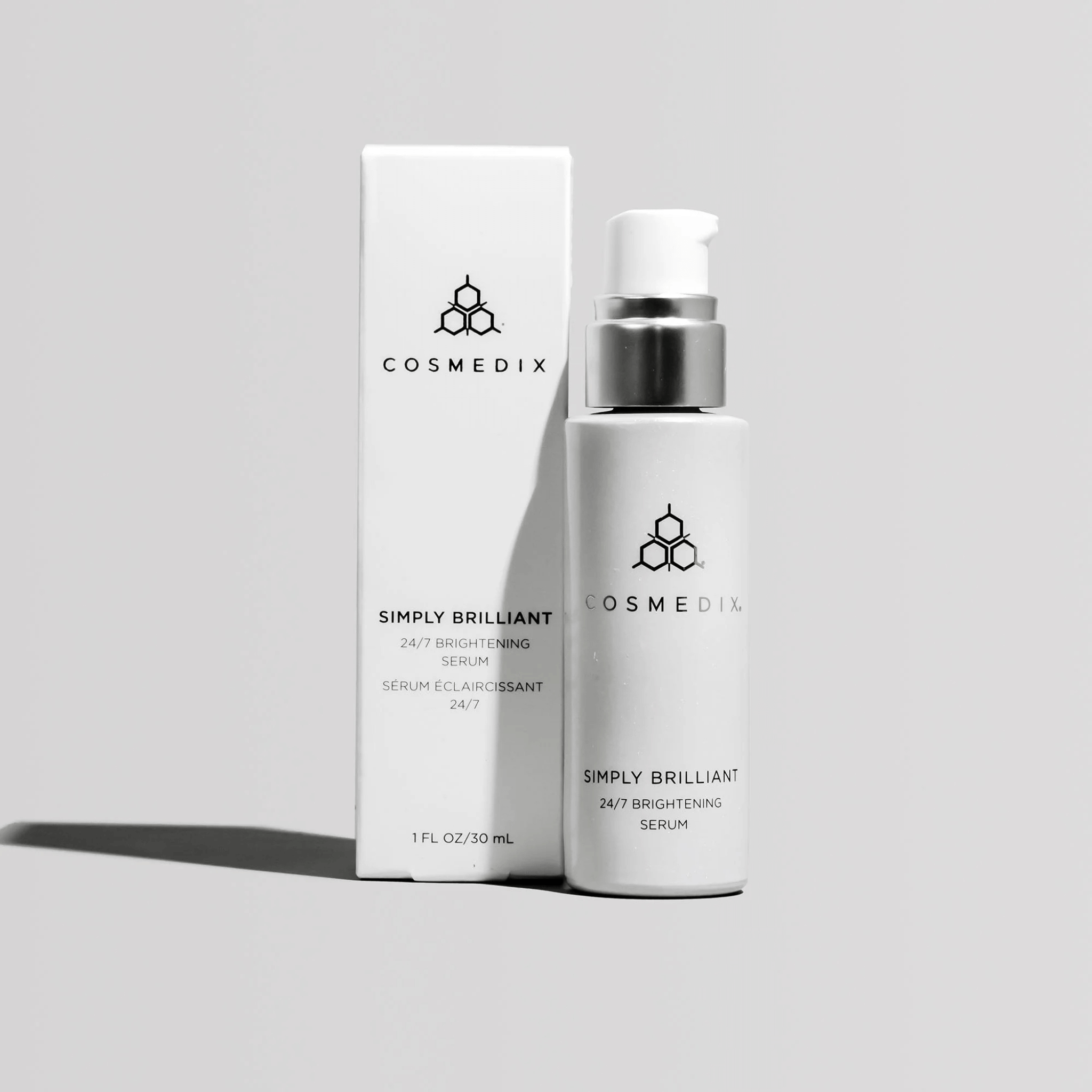 Cosmedix Simply Brilliant serum bottle and packaging on a light grey background