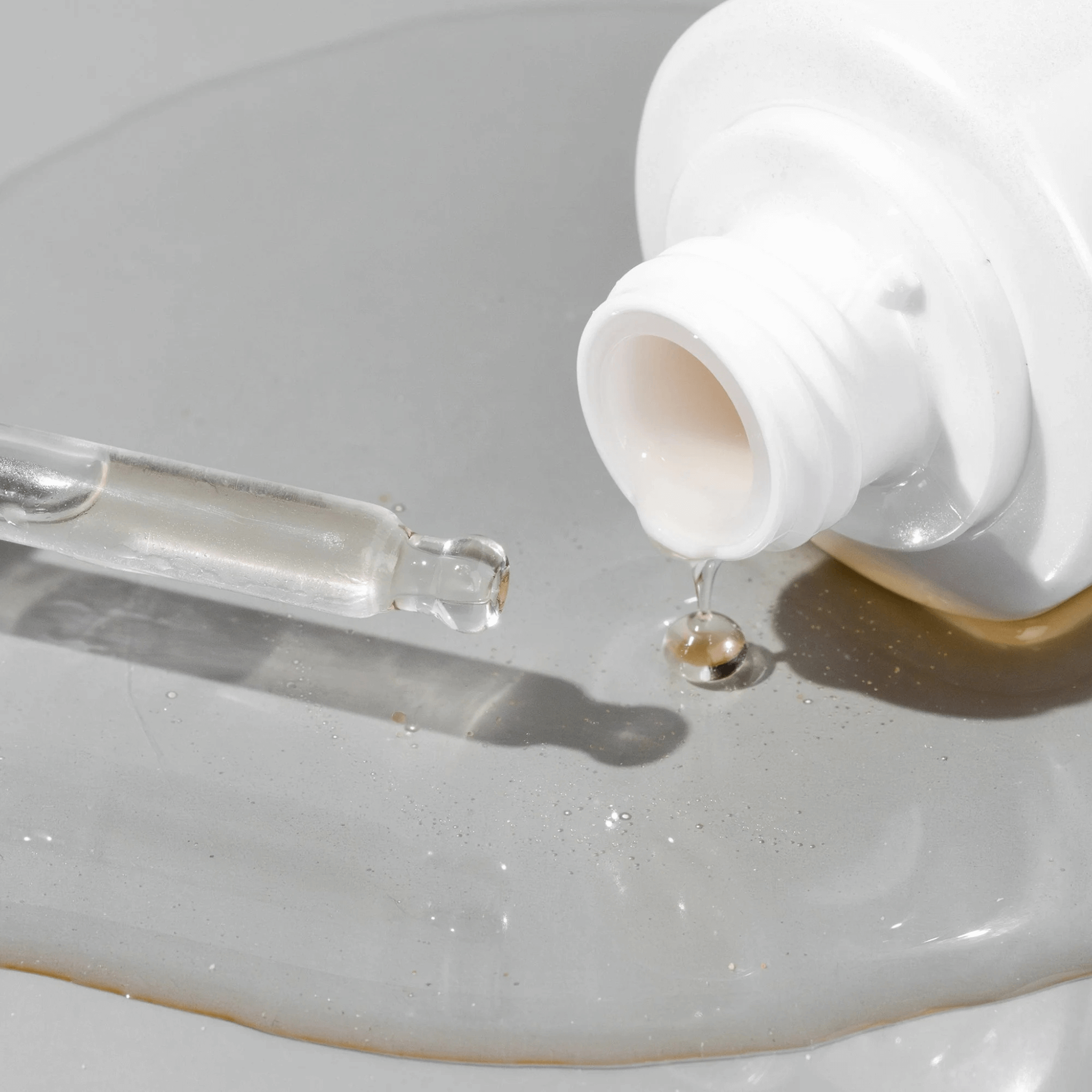 White Cosmedix Surge  bottle with dropper on a light grey background