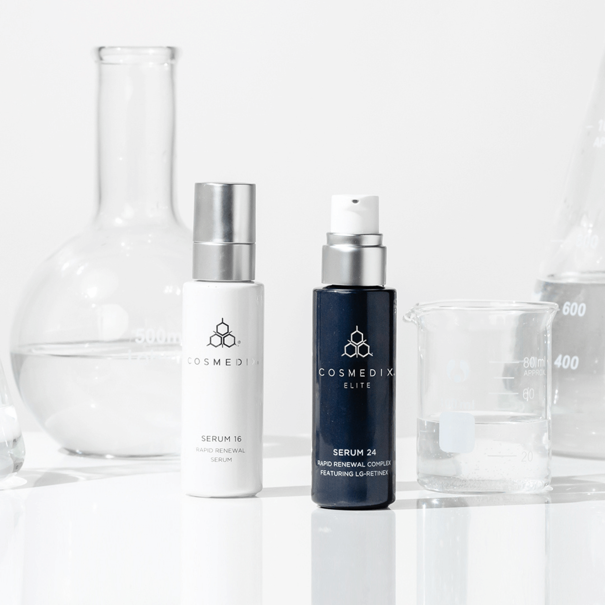 Cosmedix Serum 16 bottle and Cosmedix Elite Serum 24 bottle on a white clinical background