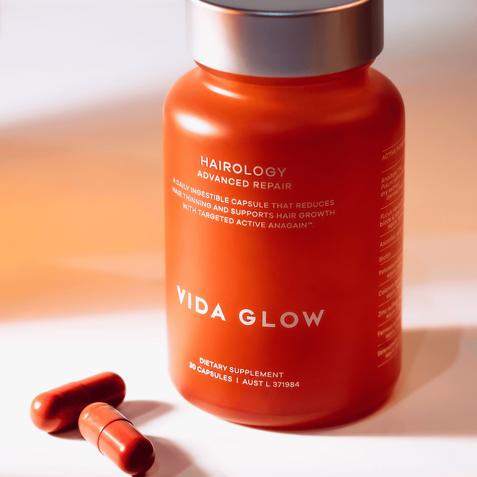 Vida Glow hairology supplement bottle with capsules on a white background
