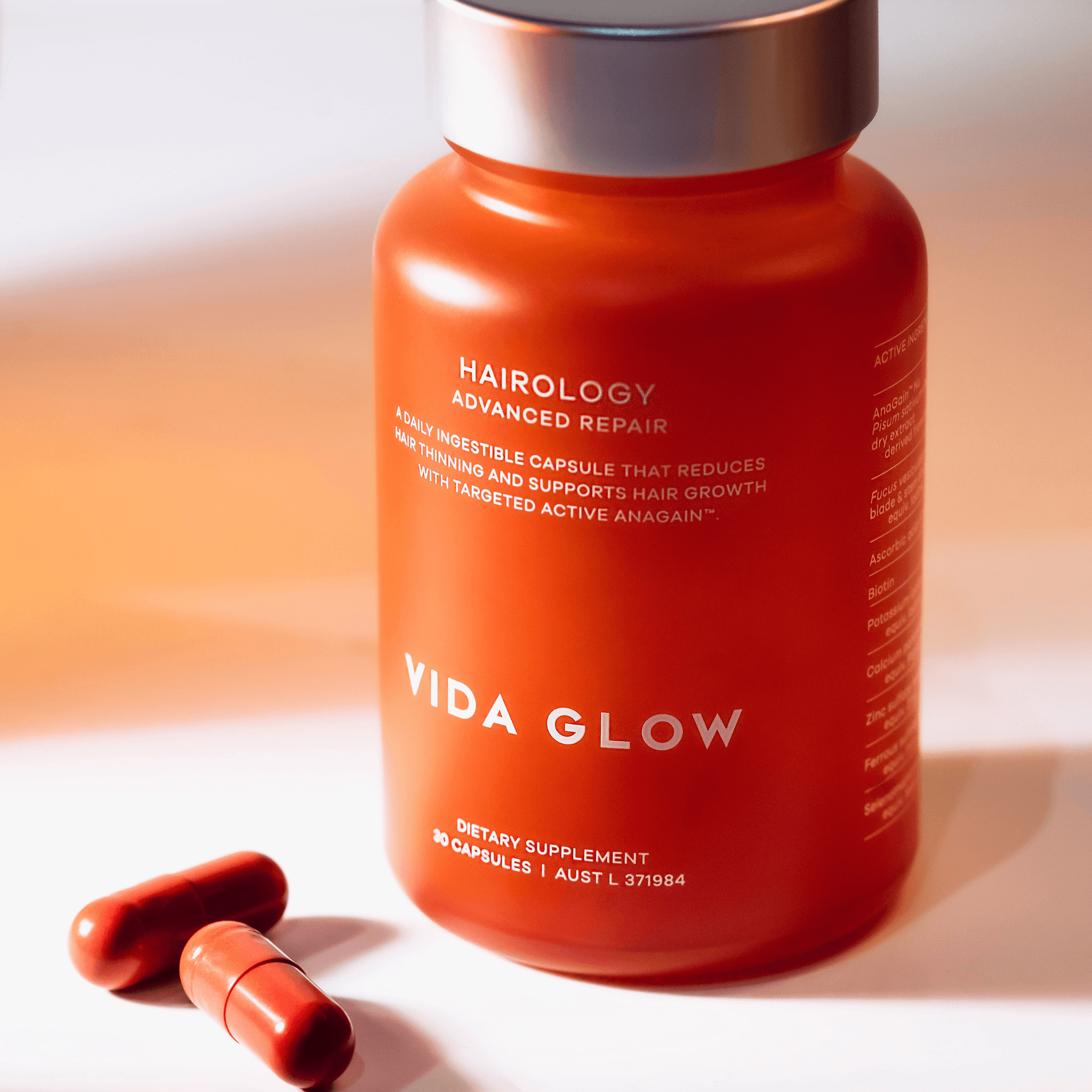 Vida Glow hairology supplement bottle with capsules on a white background