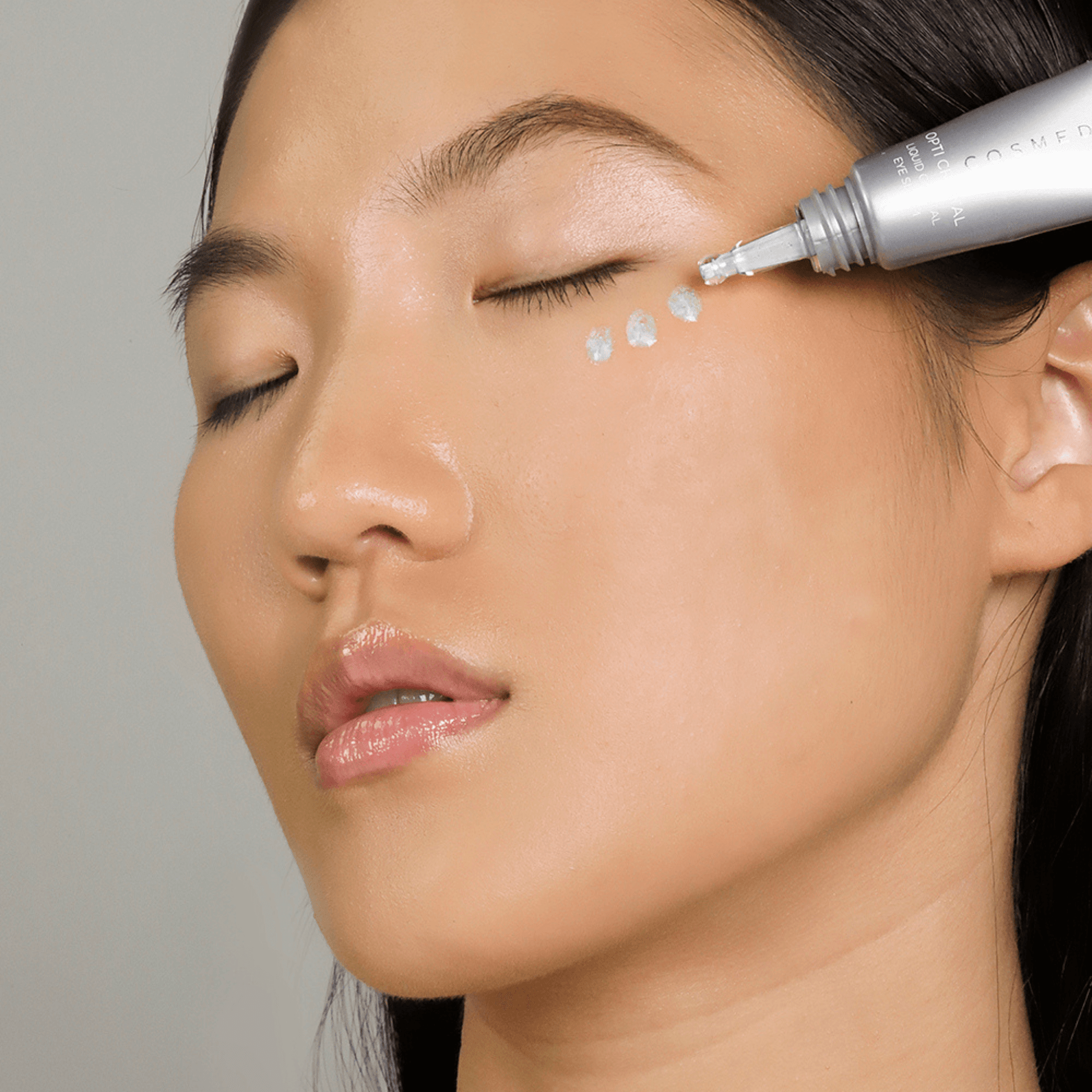 Woman applying opti crystal product to her under eye with the dropper applicator