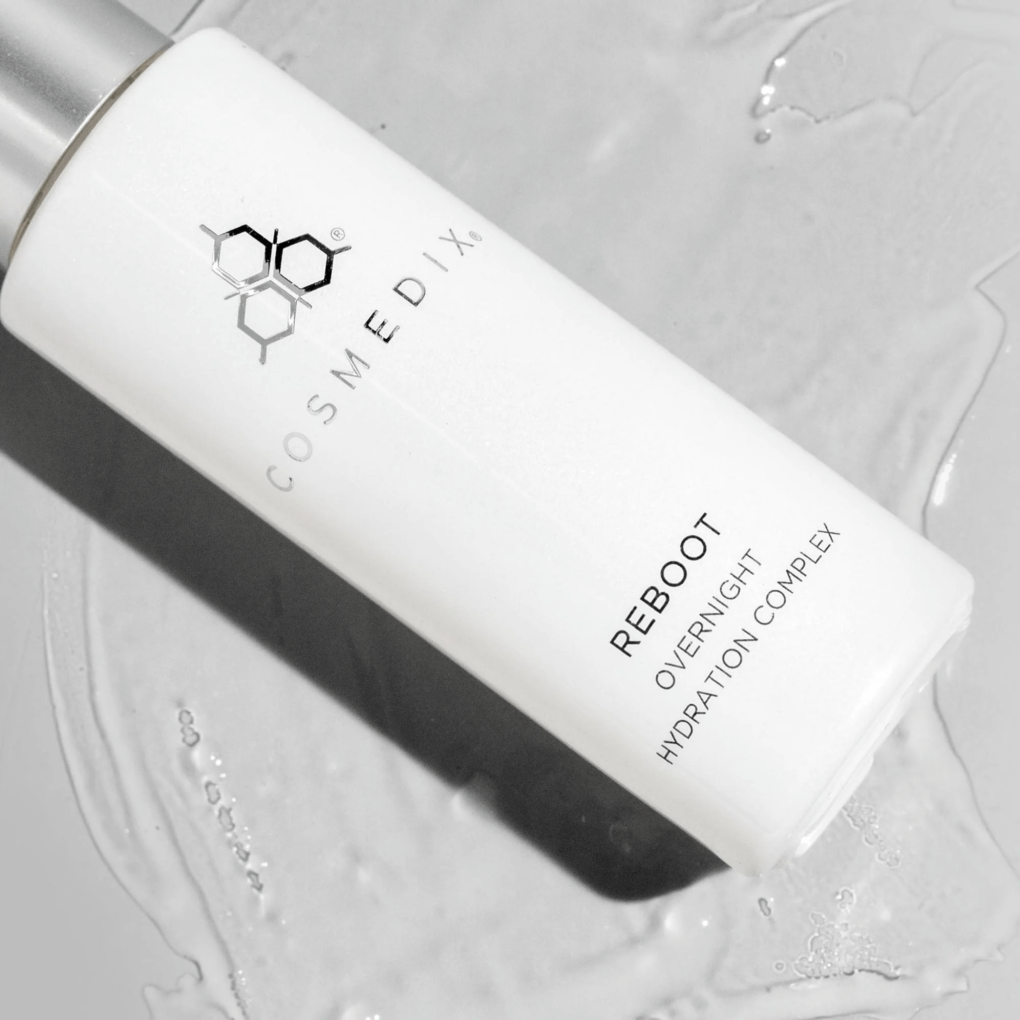 Cosmedix Reboot Overnight Hydration Complex bottle on a textured grey background