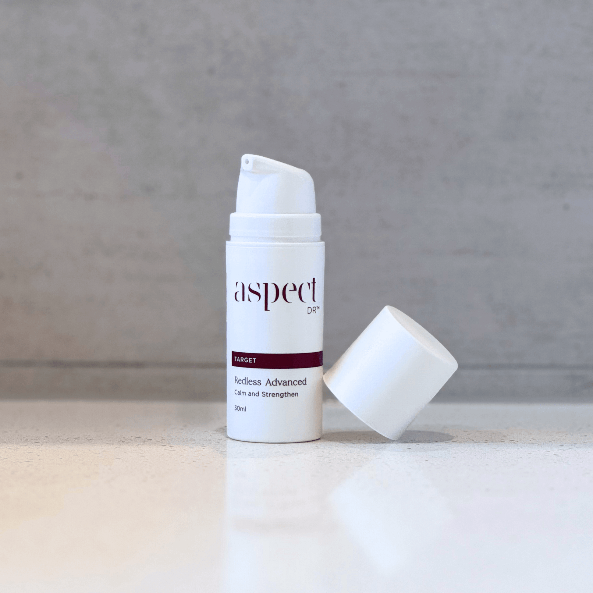 Redless Serum Aspect Dr product with lid off balancing on product