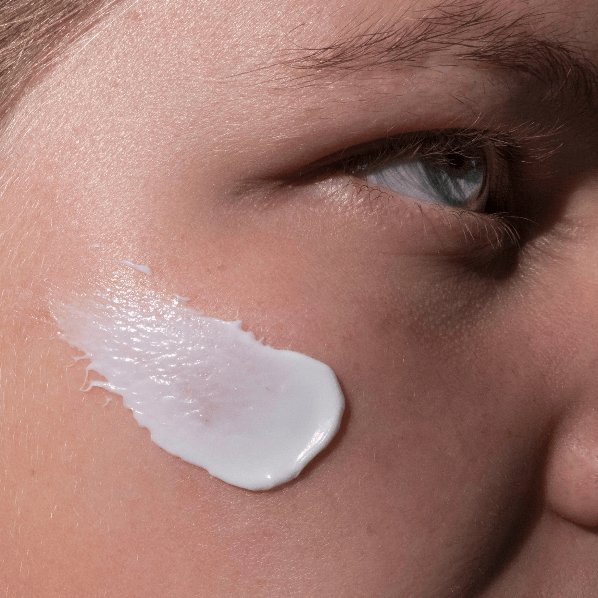 Close up of Cosmedix Restore Mask smeared on cheek of model