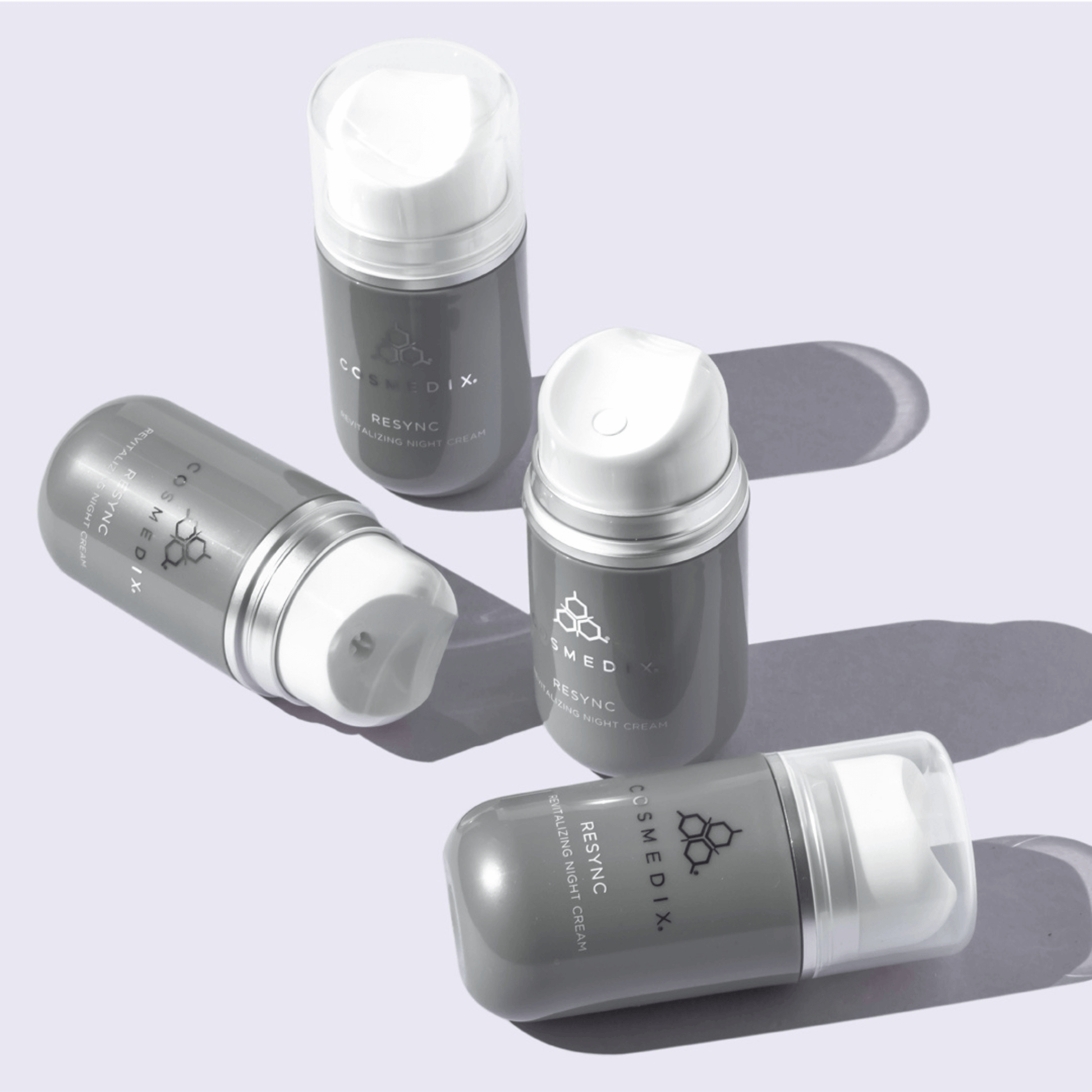 Cosmedix Resync bottles with white caps on a light purple background