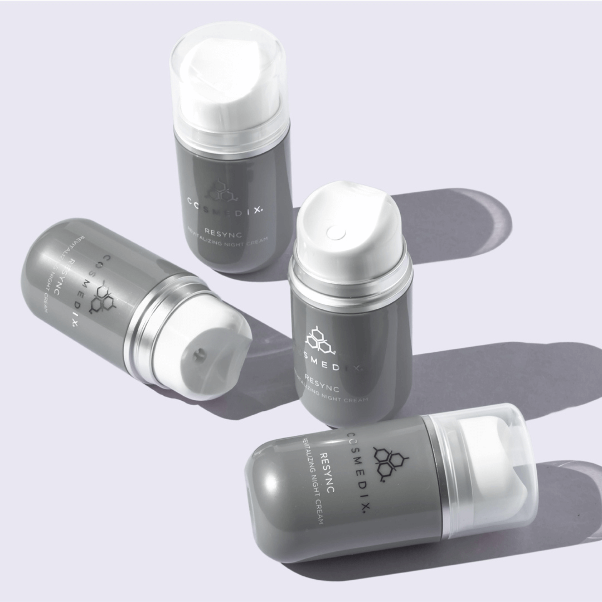 Cosmedix Resync bottles with white caps on a light purple background