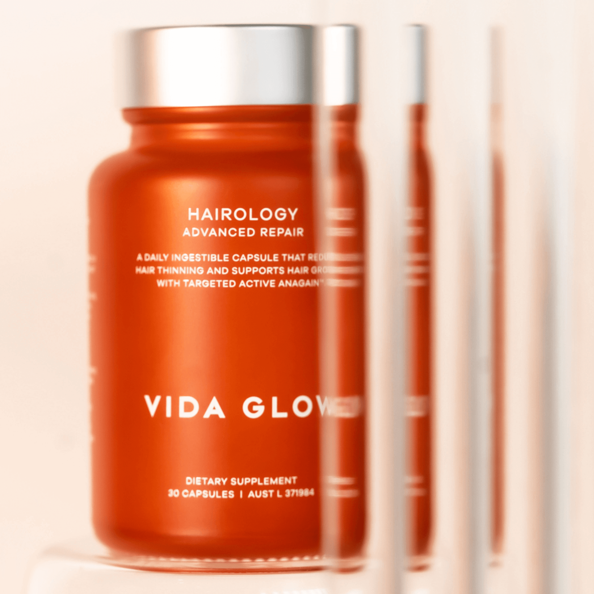 Vida Glow Hairology Advanced Repair supplement bottle on a beige background
